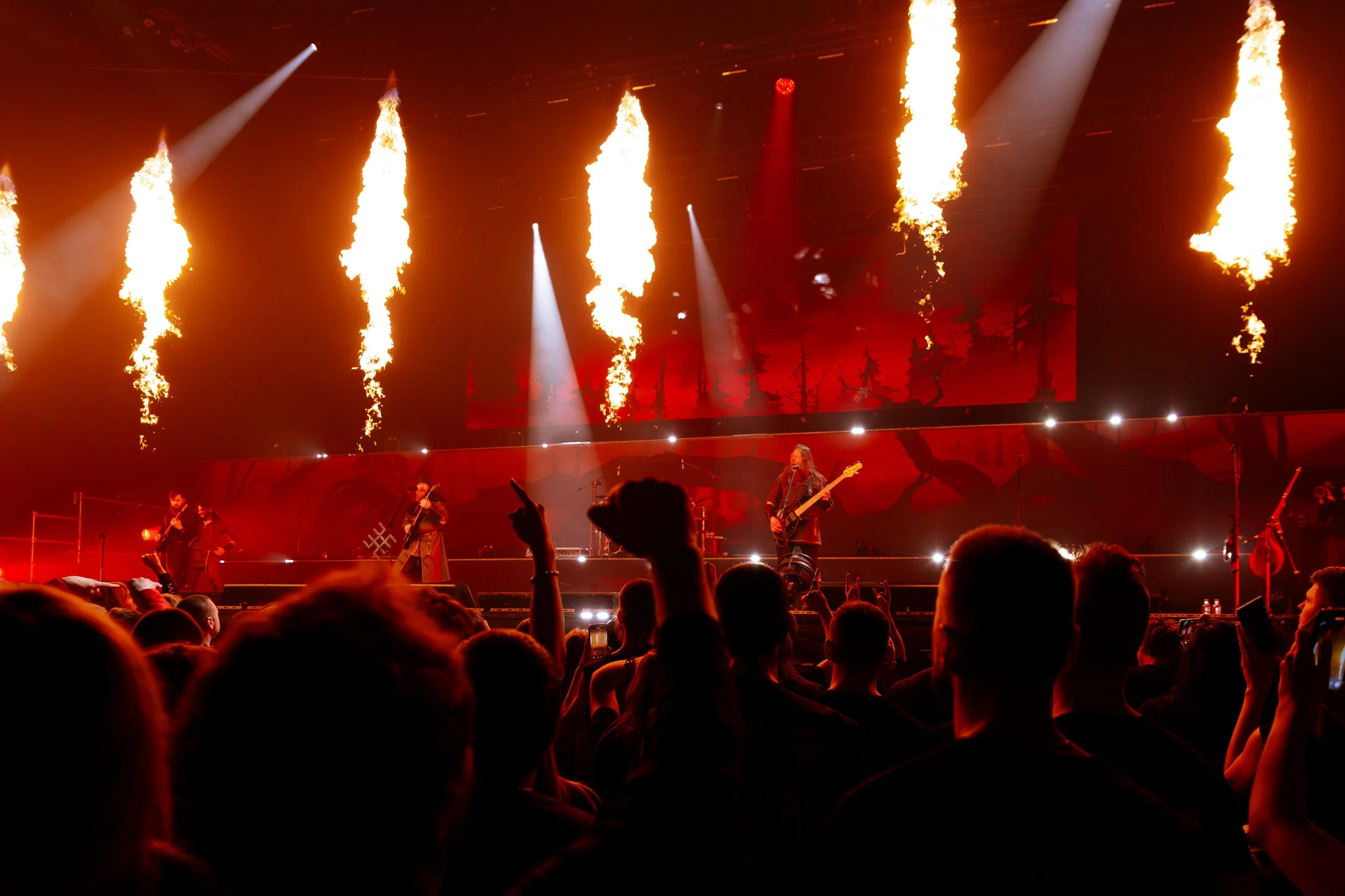 Concert scene with stage fire effects, band members playing instruments, and an audience watching.