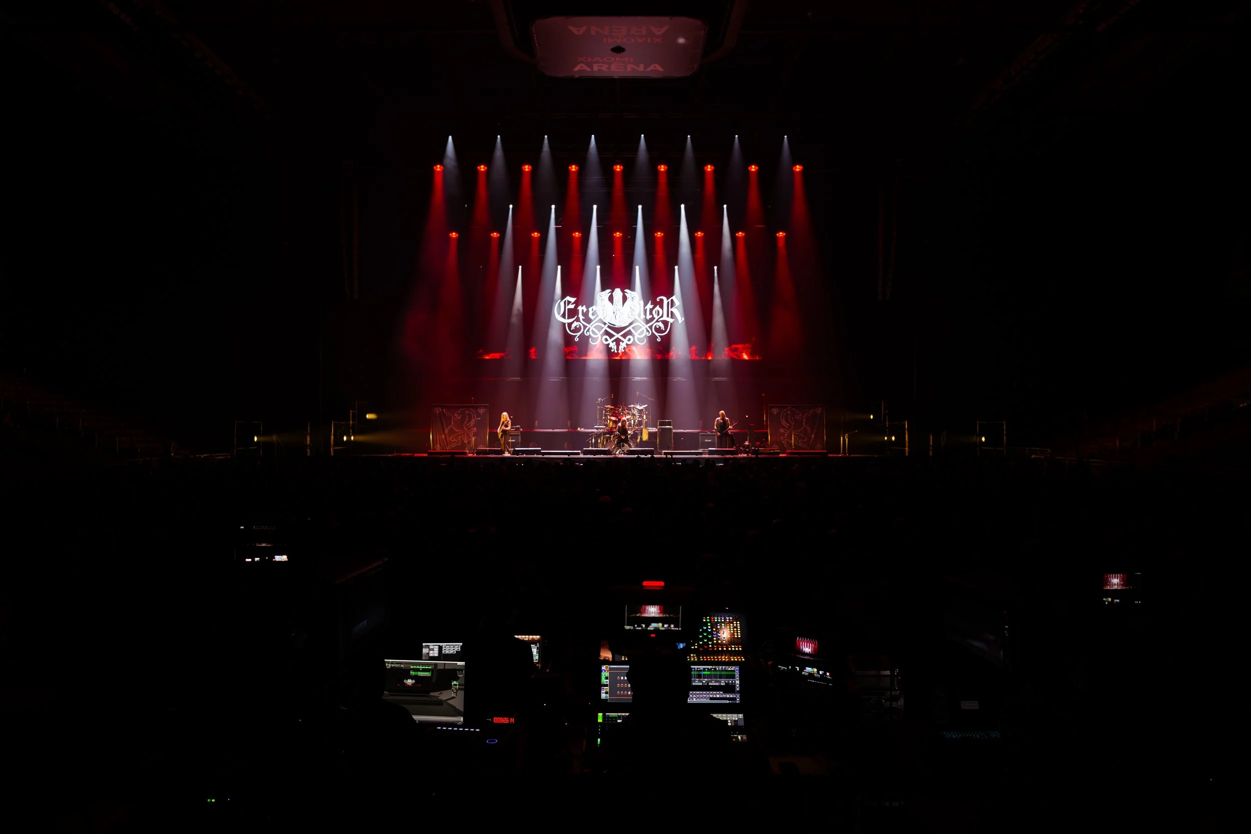 Stage with band performing under red and white lights, stage screen displays 'Creedator', venue named 'Xion Arena' at the top, and control panel visible in the foreground.