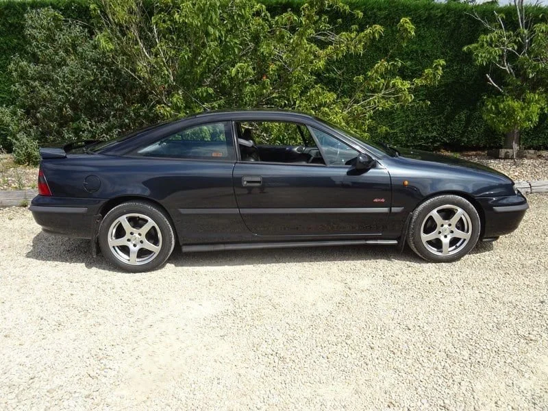 Black Vauxhall Calibra coupe side profile on gravel