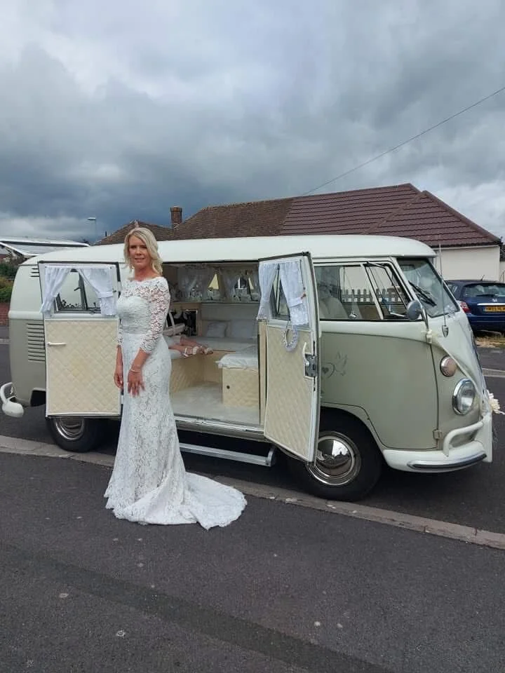 Bride in a lace wedding dress beside Olivia, our VW split-screen campervan