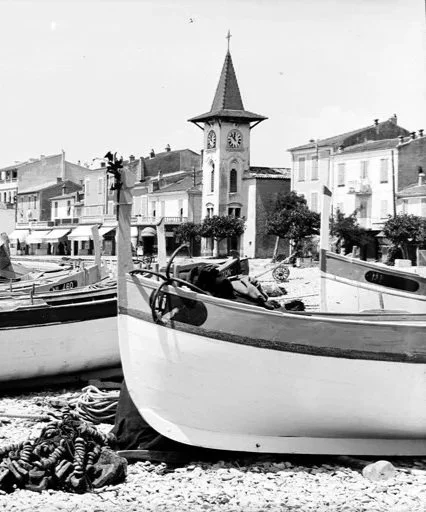 Vue ancienne du Cros-de-Cagnes avec des barques de pêche sur la plage et le village en arrière-plan.