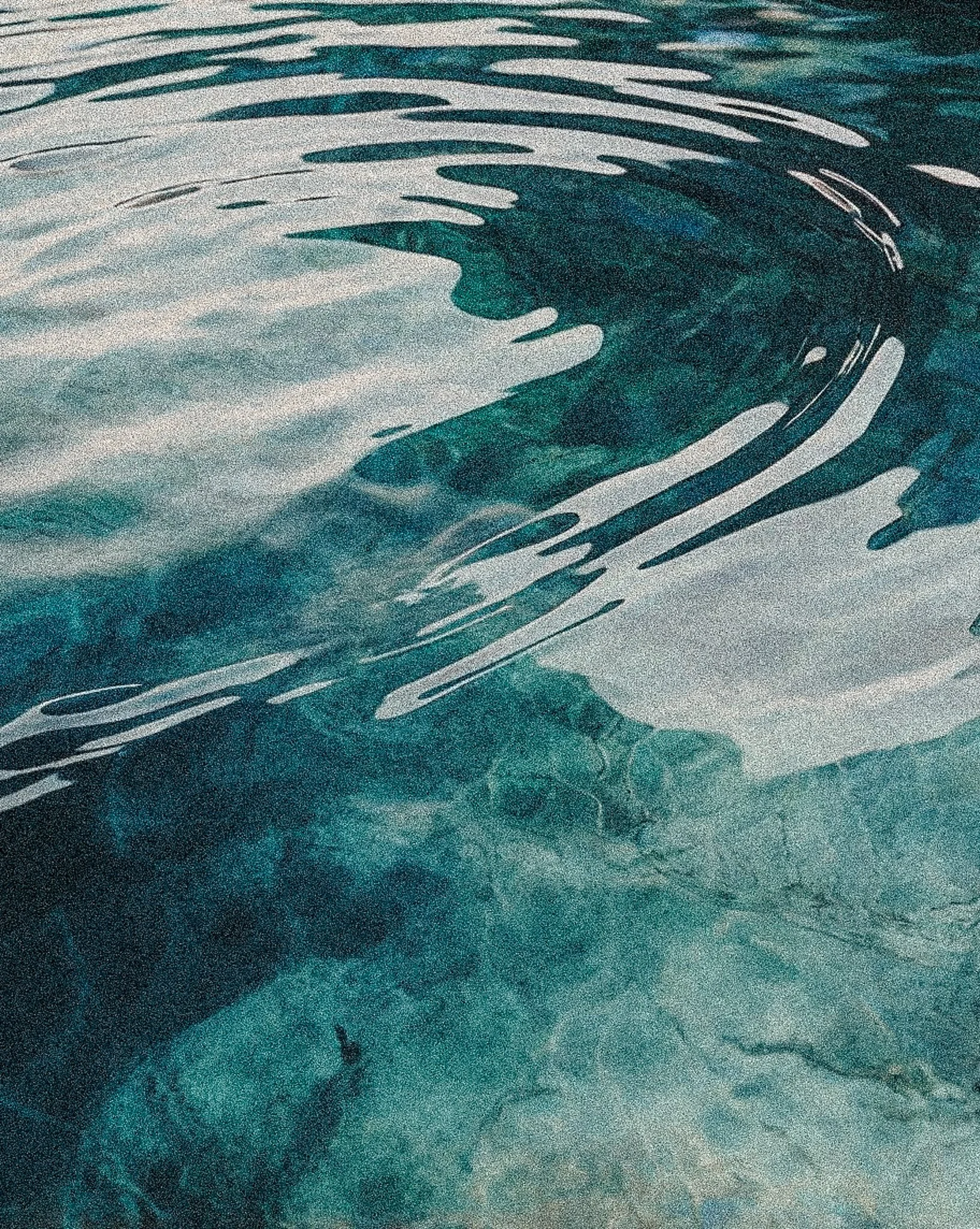 Aerial view of the ocean with visible waves and ripples on the water's surface.