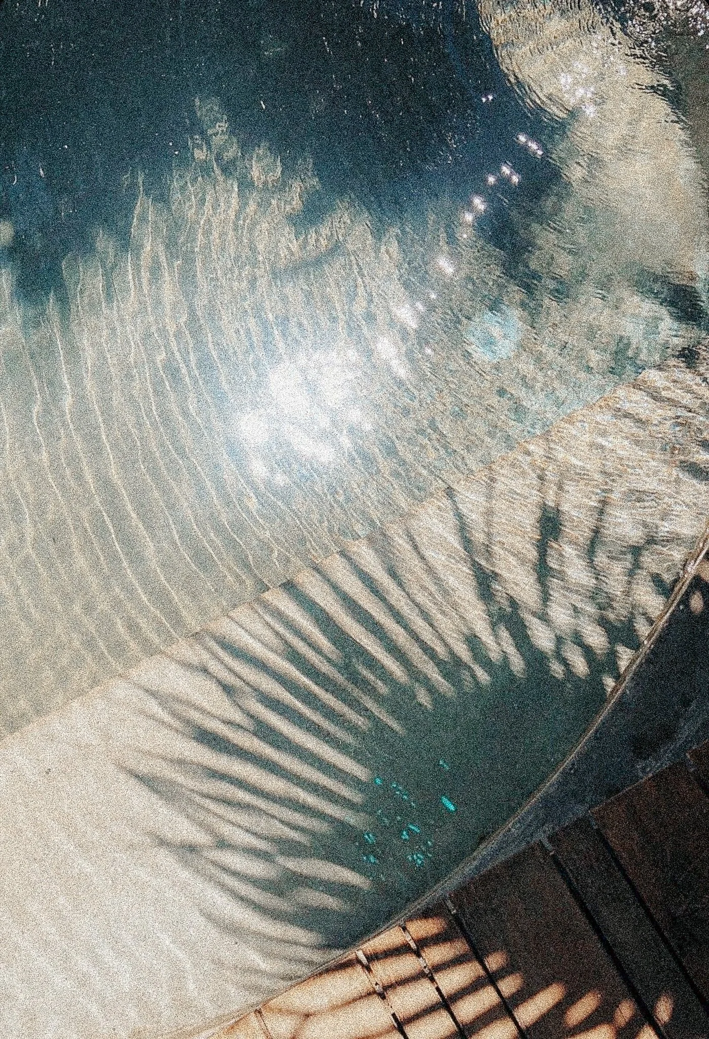Close-up image of metallic surface with ribbed texture and reflections of light, possibly part of a large equipment or machinery.