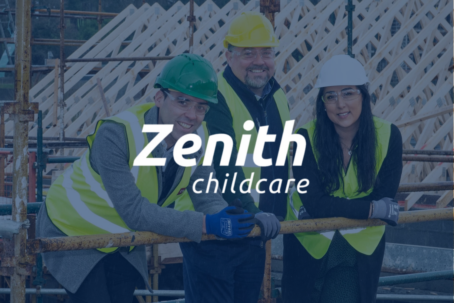 Three construction workers in safety vests and helmets on a construction site with wooden framework in background.