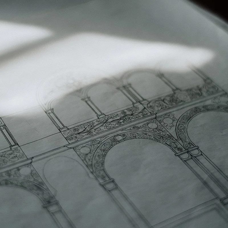 A detailed architectural drawing or blueprint of a building with arches and decorative elements.