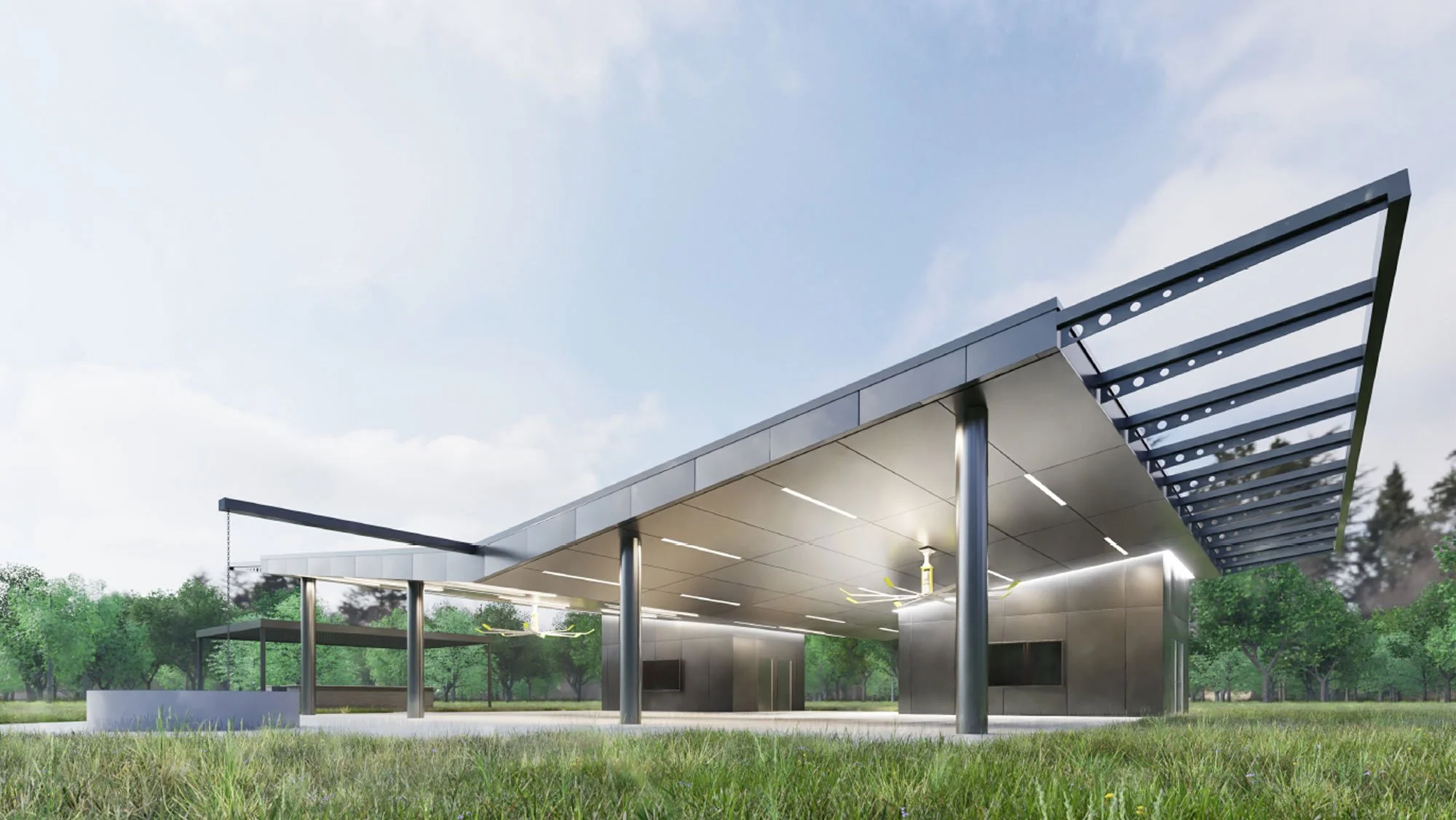 Modern outdoor pavilion with a flat roof, supported by metal columns, featuring an overhanging awning and ceiling fans, set in a grassy park with trees in the background on a clear day.