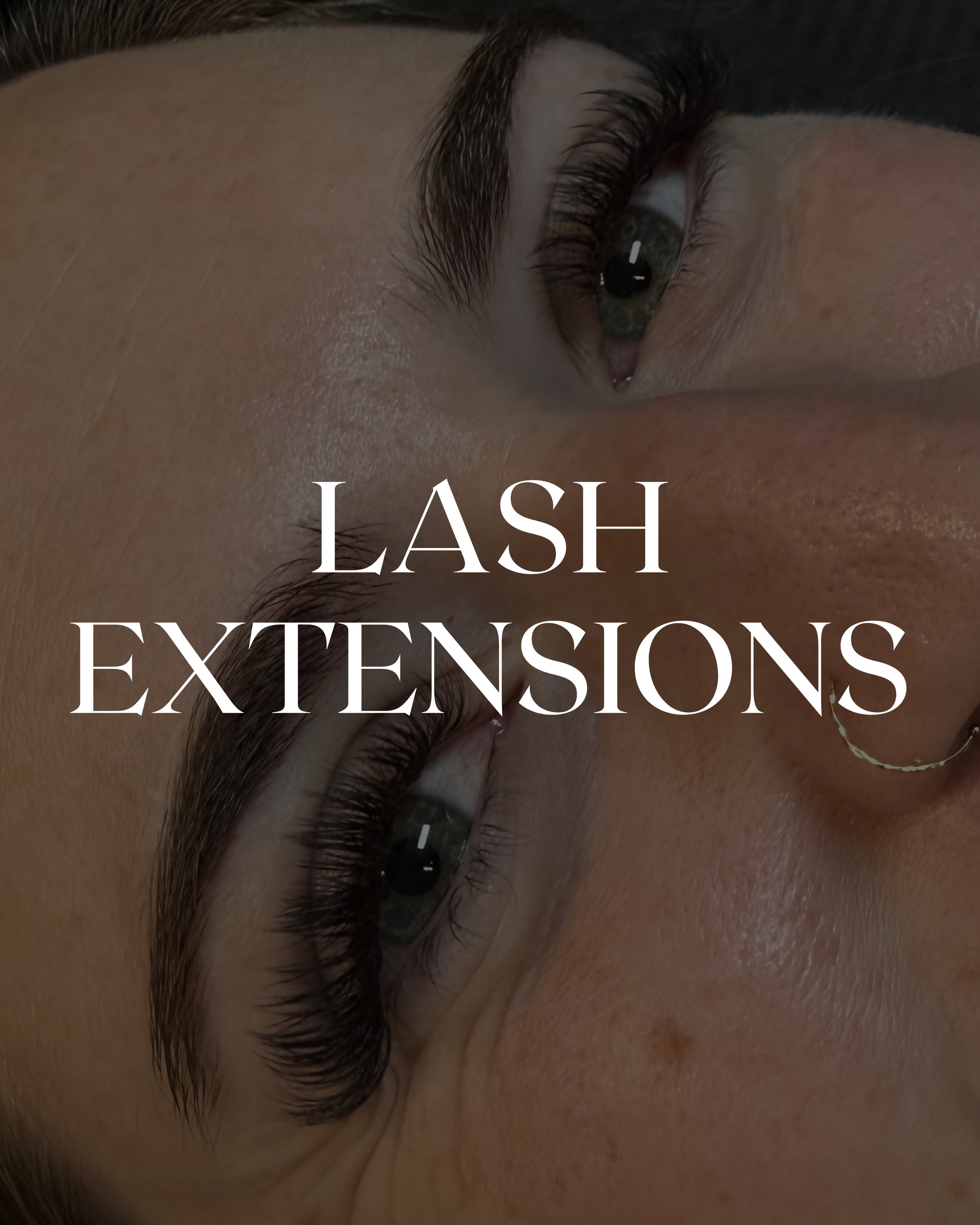 Close-up of a woman's eye with long eyelash extensions and eye makeup, showing the eyebrow and surrounding skin.