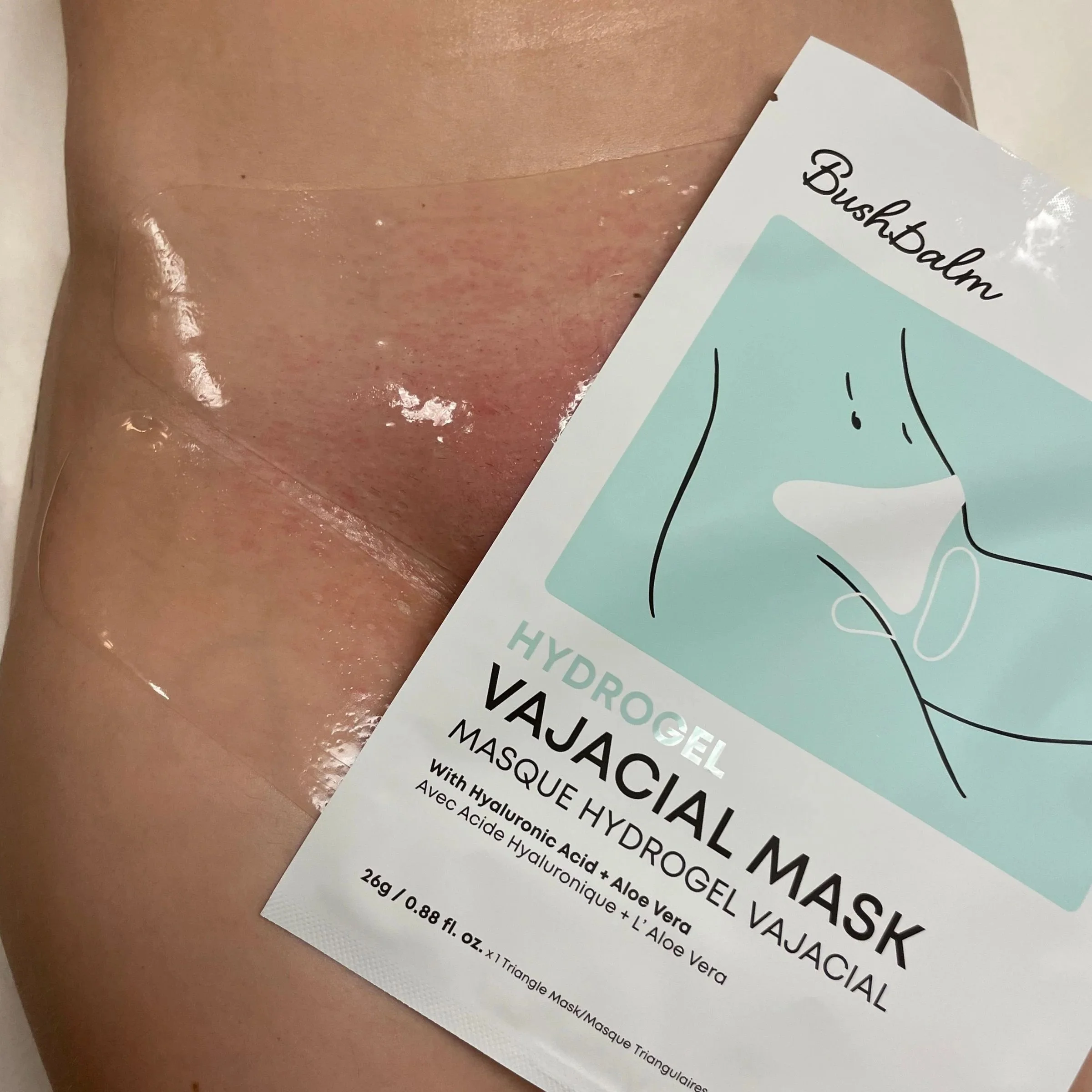 A close-up of a person's cheek with a sheet mask applied, partially covered by a white paper label that reads 'Boushbalm HYDROGEL MASK'.