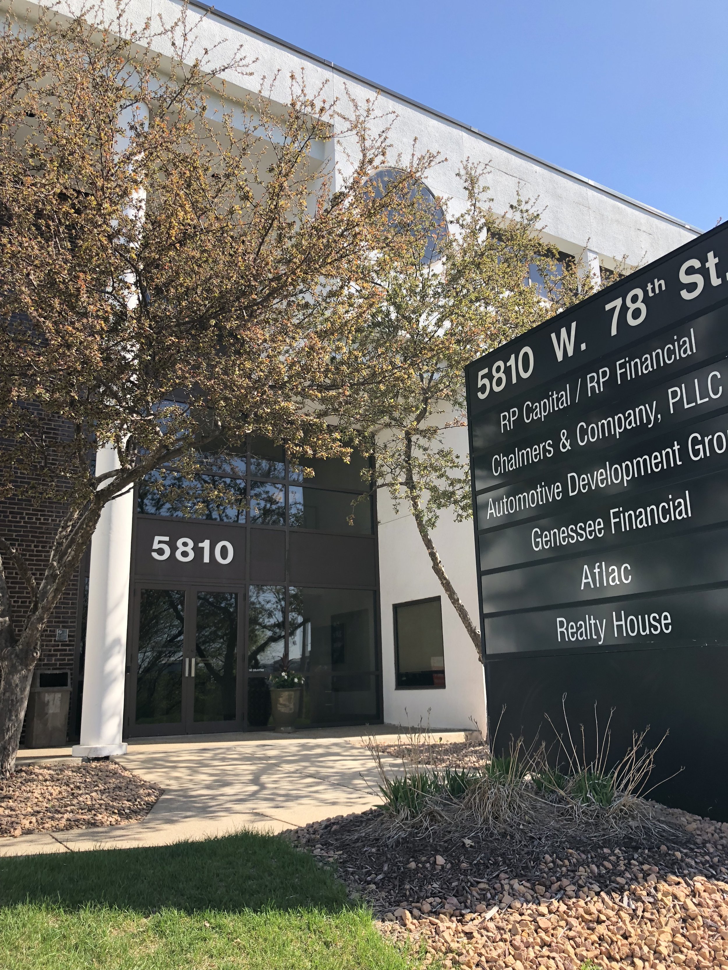 Office building with the address 5810 W. 78th St and a large sign listing tenants including RP Capital, Chalmers & Company, Automotive Development Group, Genesee Financial, Aflac, and Realty House.