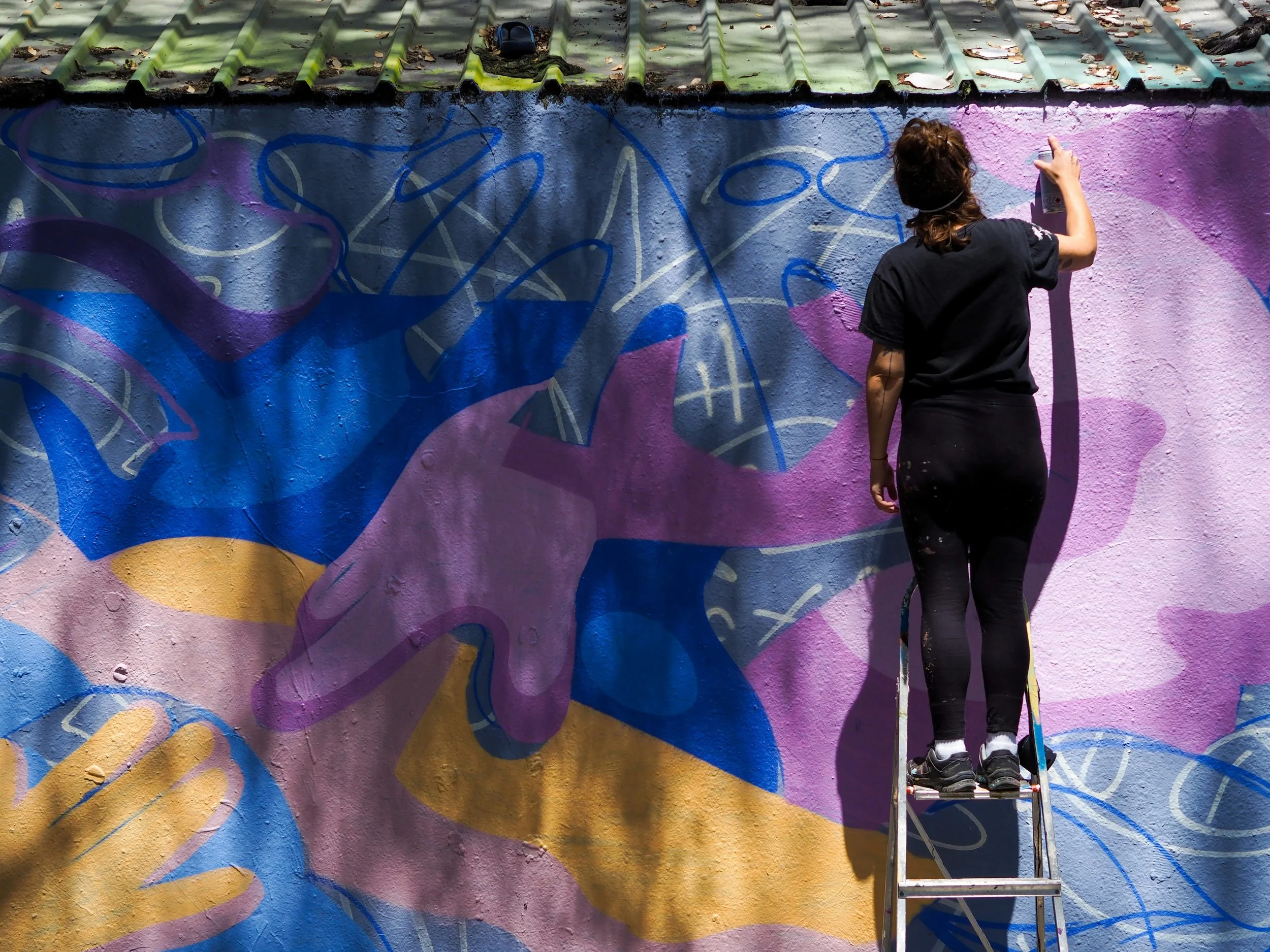 Artista local pintando un mural en un barrio de Barcelona