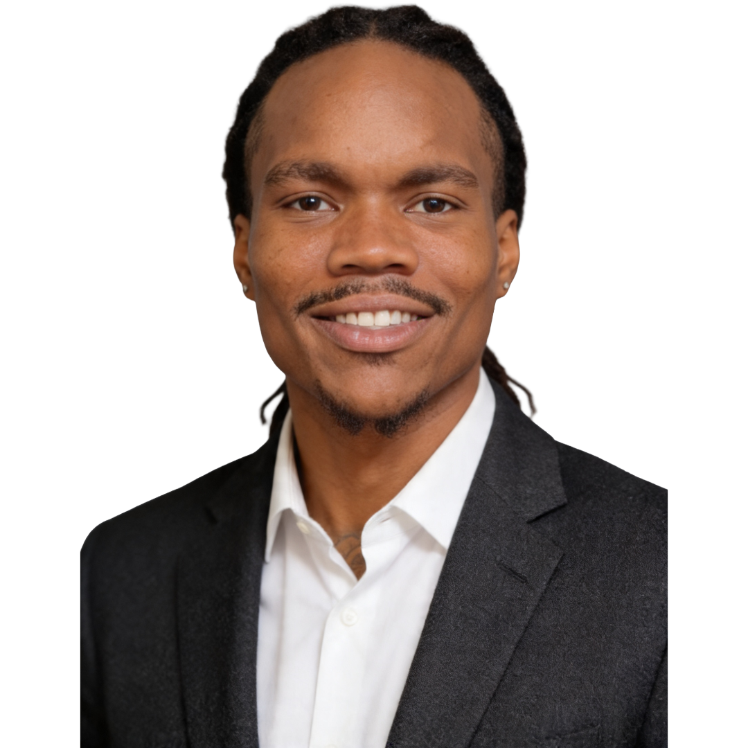 Portrait of a smiling African American man with dreadlocks, wearing a black blazer and white shirt against a plain white background.