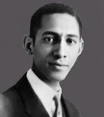 Black and white portrait of a man wearing a suit and tie, looking directly at the camera