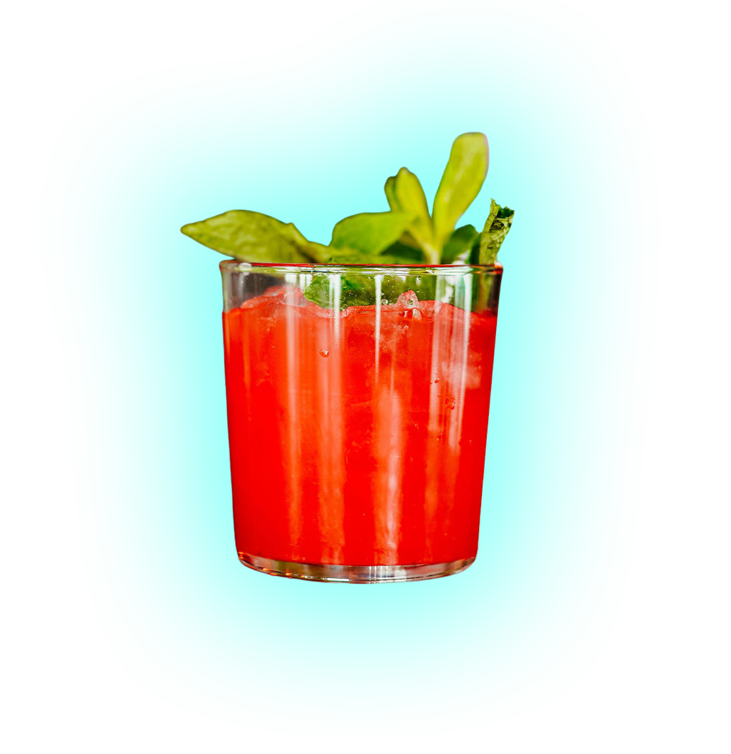 Red cocktail in a glass garnished with fresh green mint leaves against a blue background.