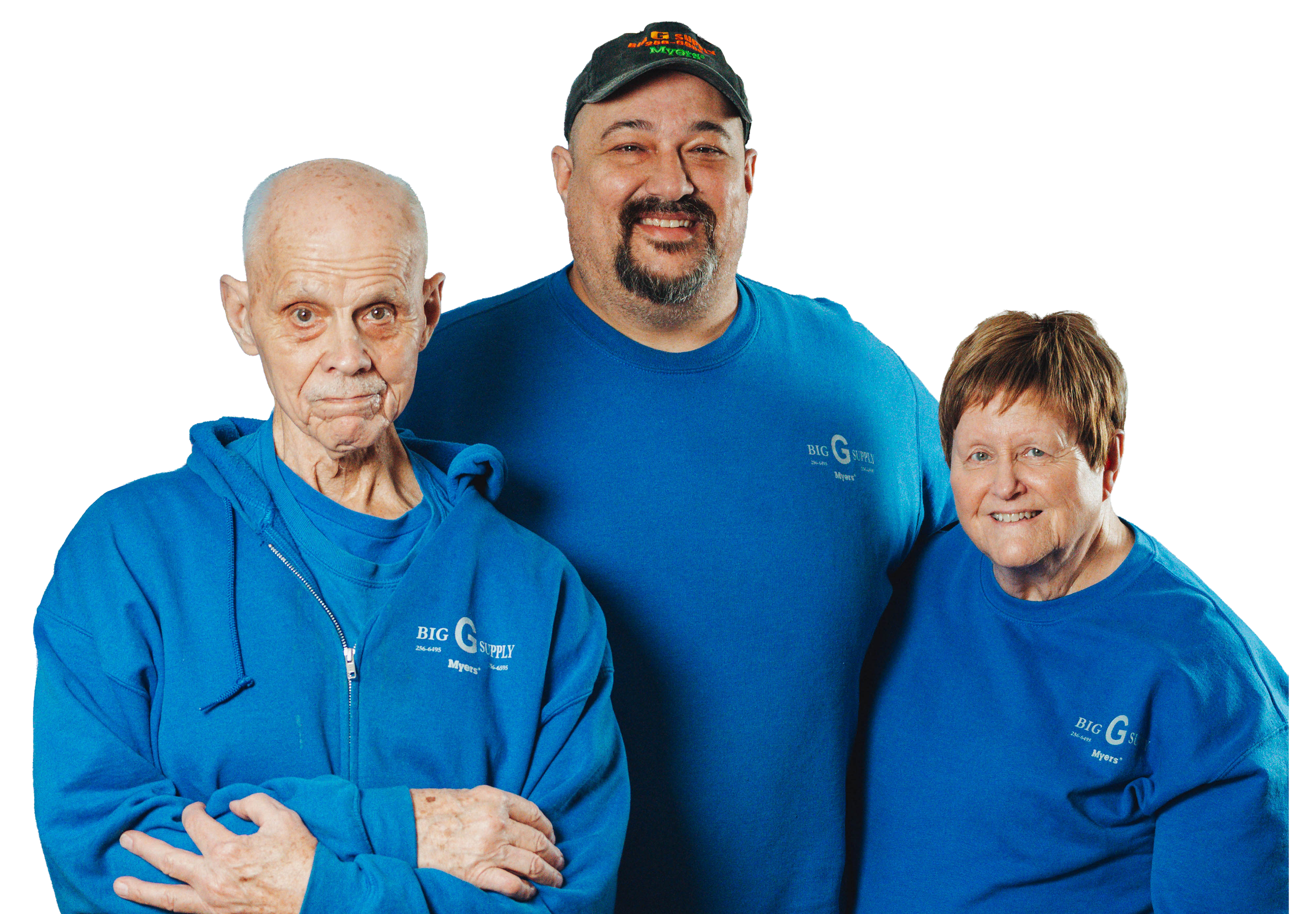 Three people, two women and one man, wearing blue shirts and hoodies with 'Big G Supply Myer's' logo, standing together and smiling.