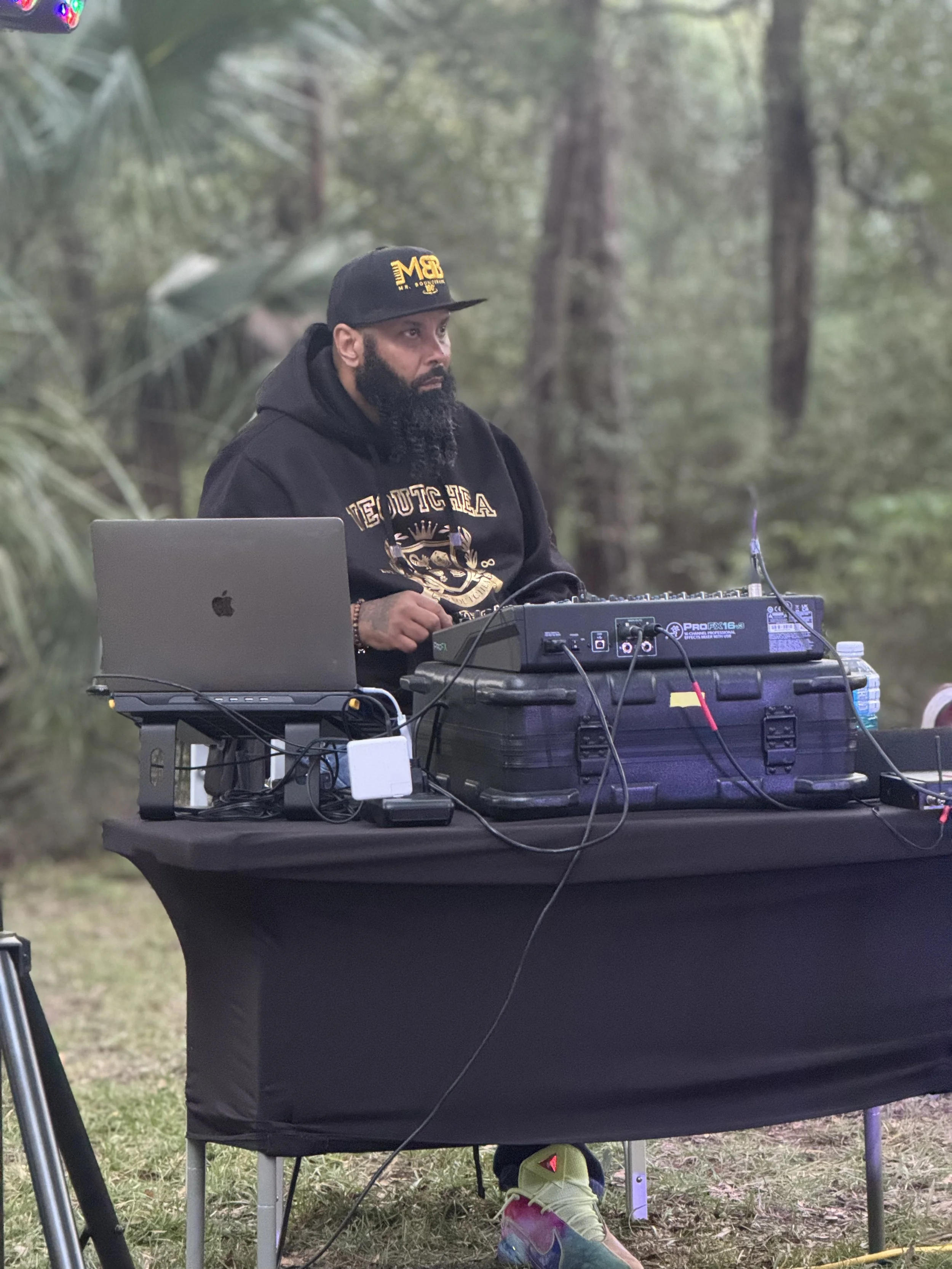 André "Mr. Bounceback" Amigér behind a DJ booth outside.