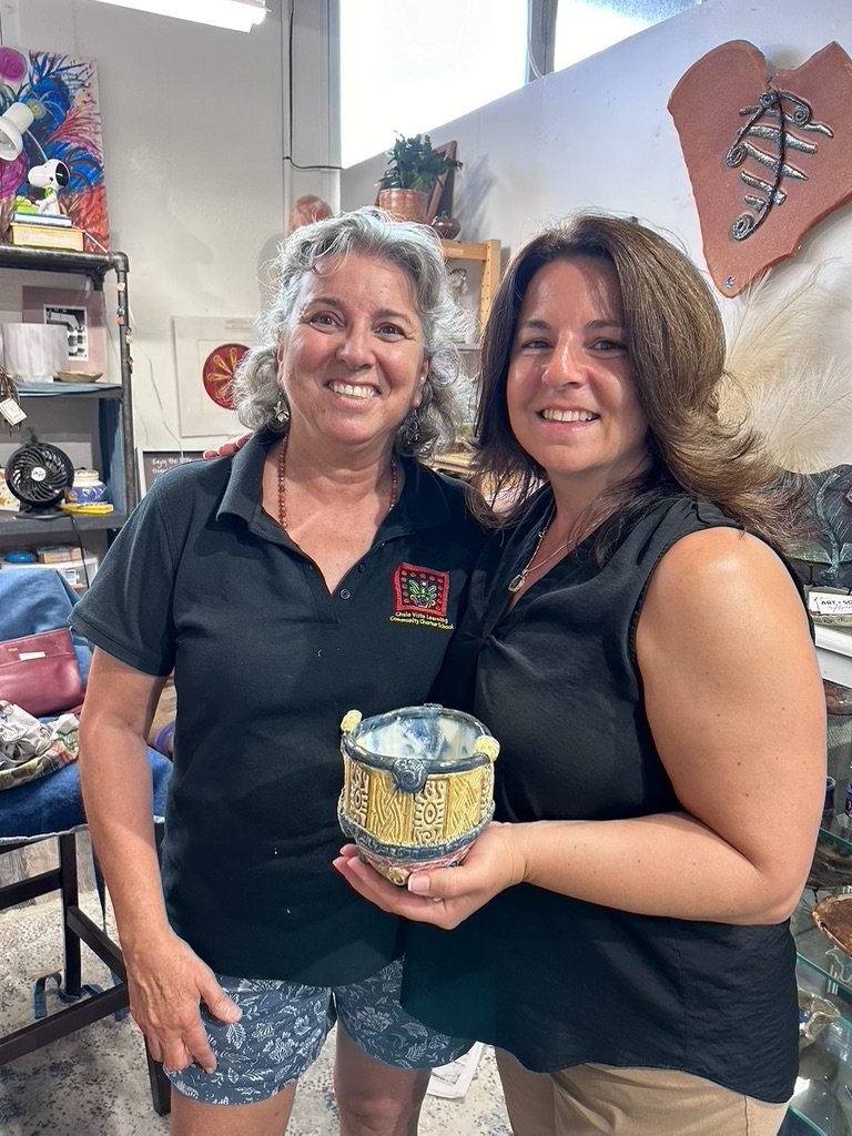 Two women smiling and holding Story Bowl 1, a colorful stoneware bowl by Karen Cadiero-Kaplan.