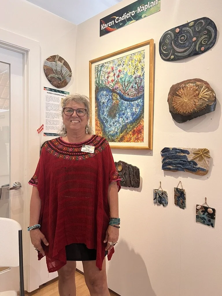 Karen standing in front of her artwork at the studio