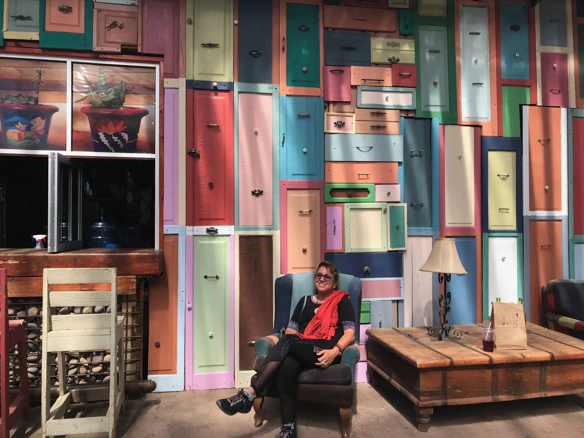 Karen sitting in a chair in front of a wall of colorful doors