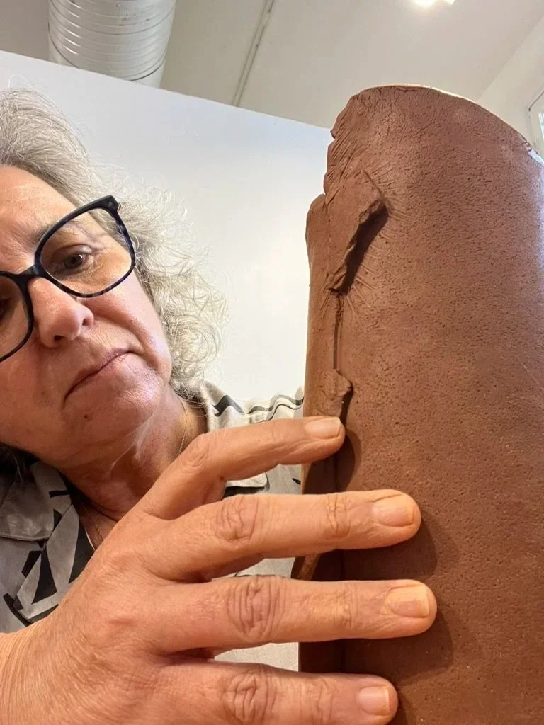 Karen with her hands shaping artwork