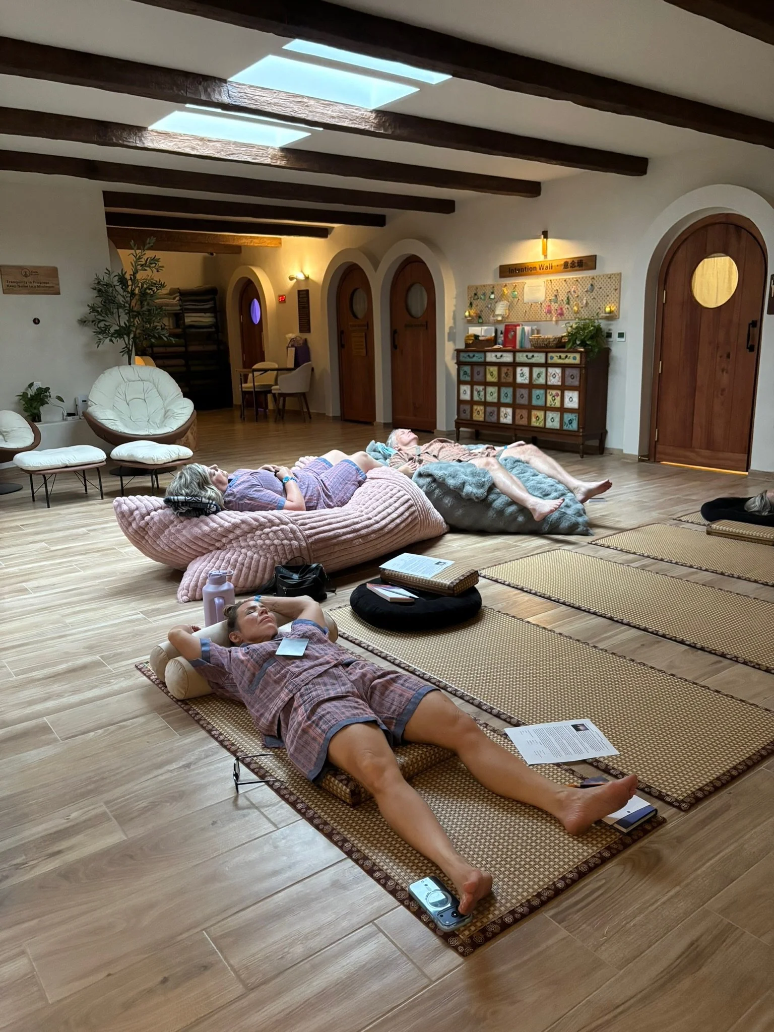 Three clients relaxing in a beautiful yoga studio as they take one of Karen's healing classes in San Diego