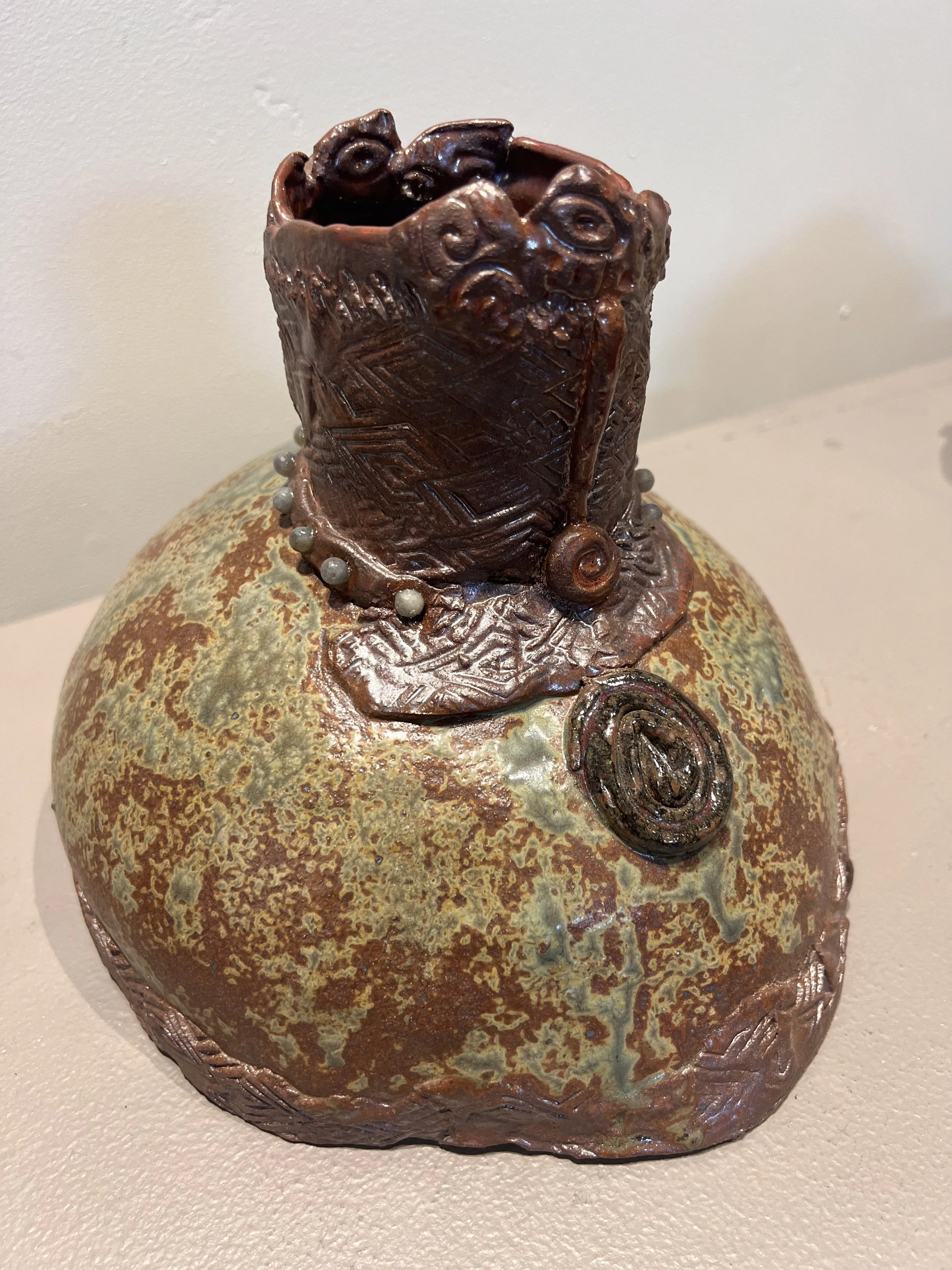Stoneware vase with goddess-like form and earthy glaze, suggesting strength and courage.