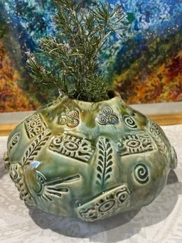 Side view of Sacred Sister stoneware water vessel with textured green glaze and plant-like form.