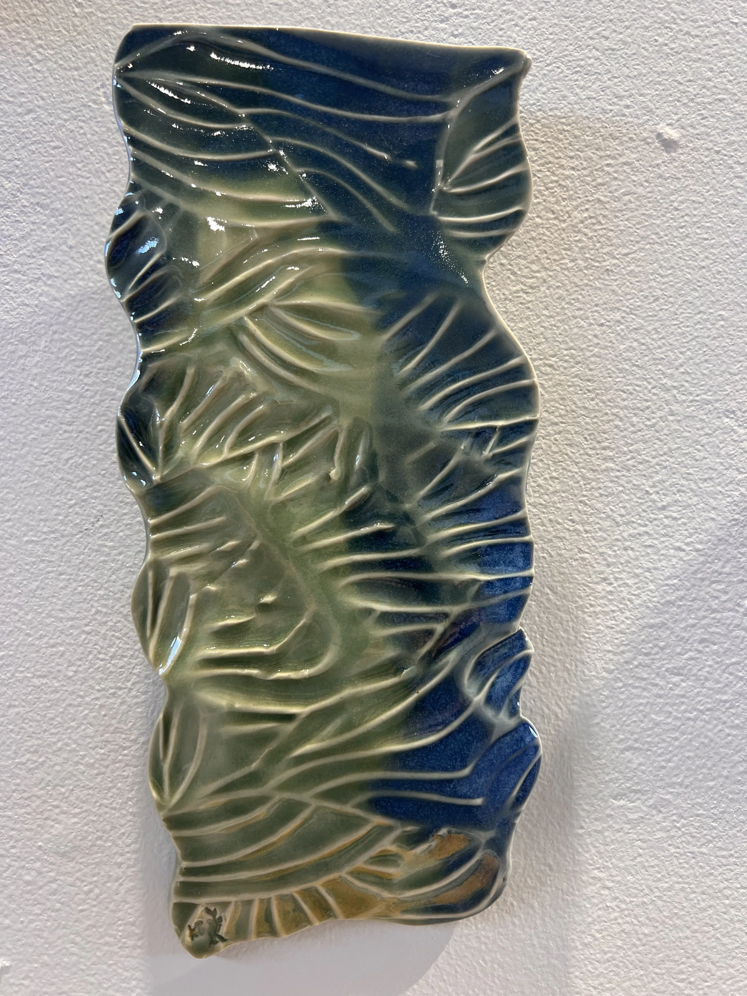 Second blue-green stoneware wall piece with curved ridges and riverlike flowing texture.