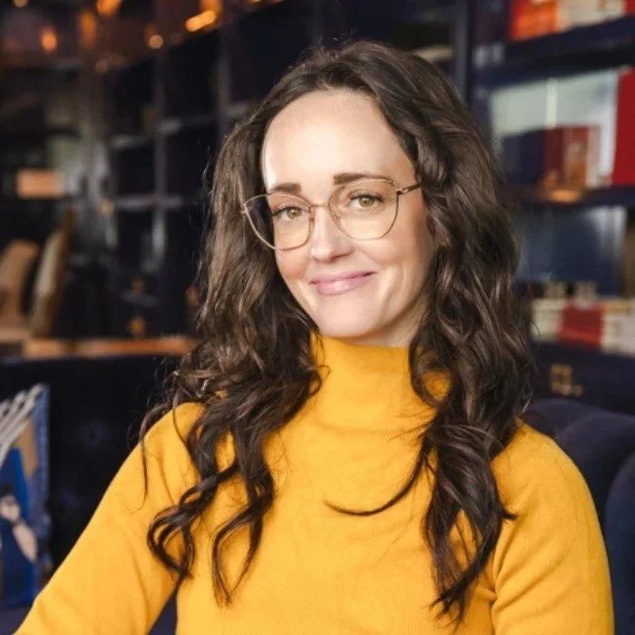 Jess Rhodes headshot in yellow sweater