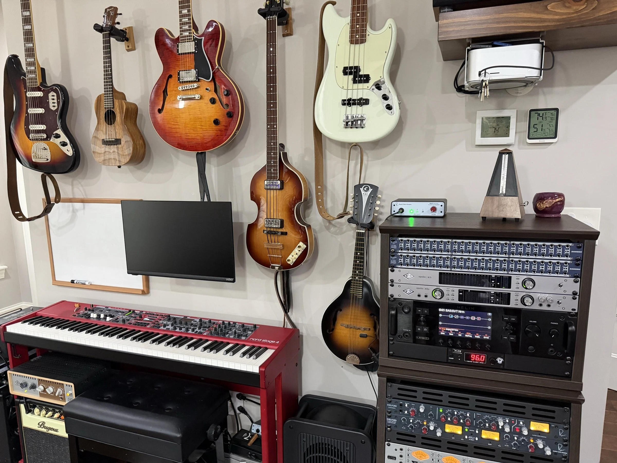 Guitars, basses, ukulele, red keyboard and recording equipment in the Audio Sails studio.