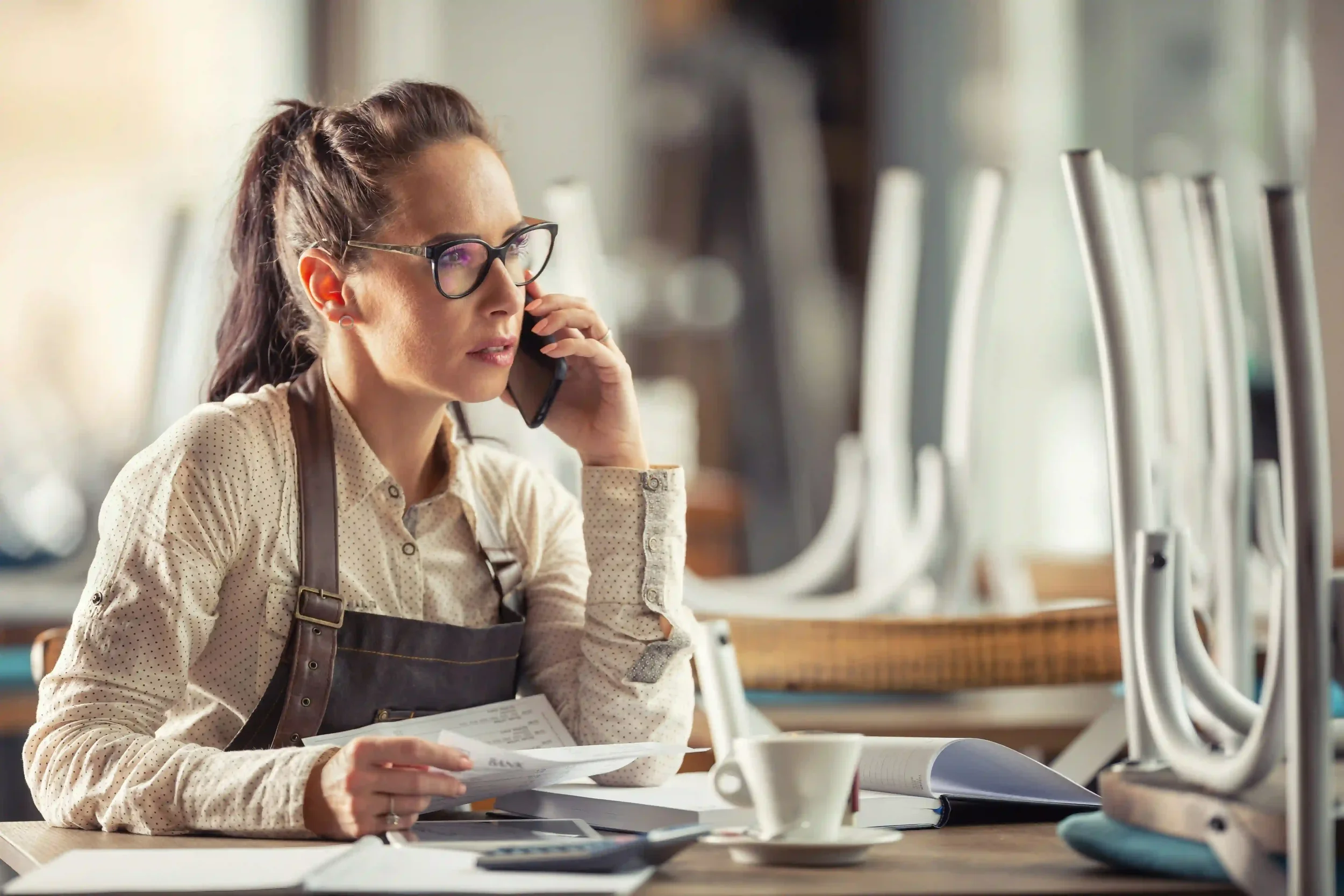 California Restaurant owner reviewing her insurance policies and speaking with her agent on the phone
