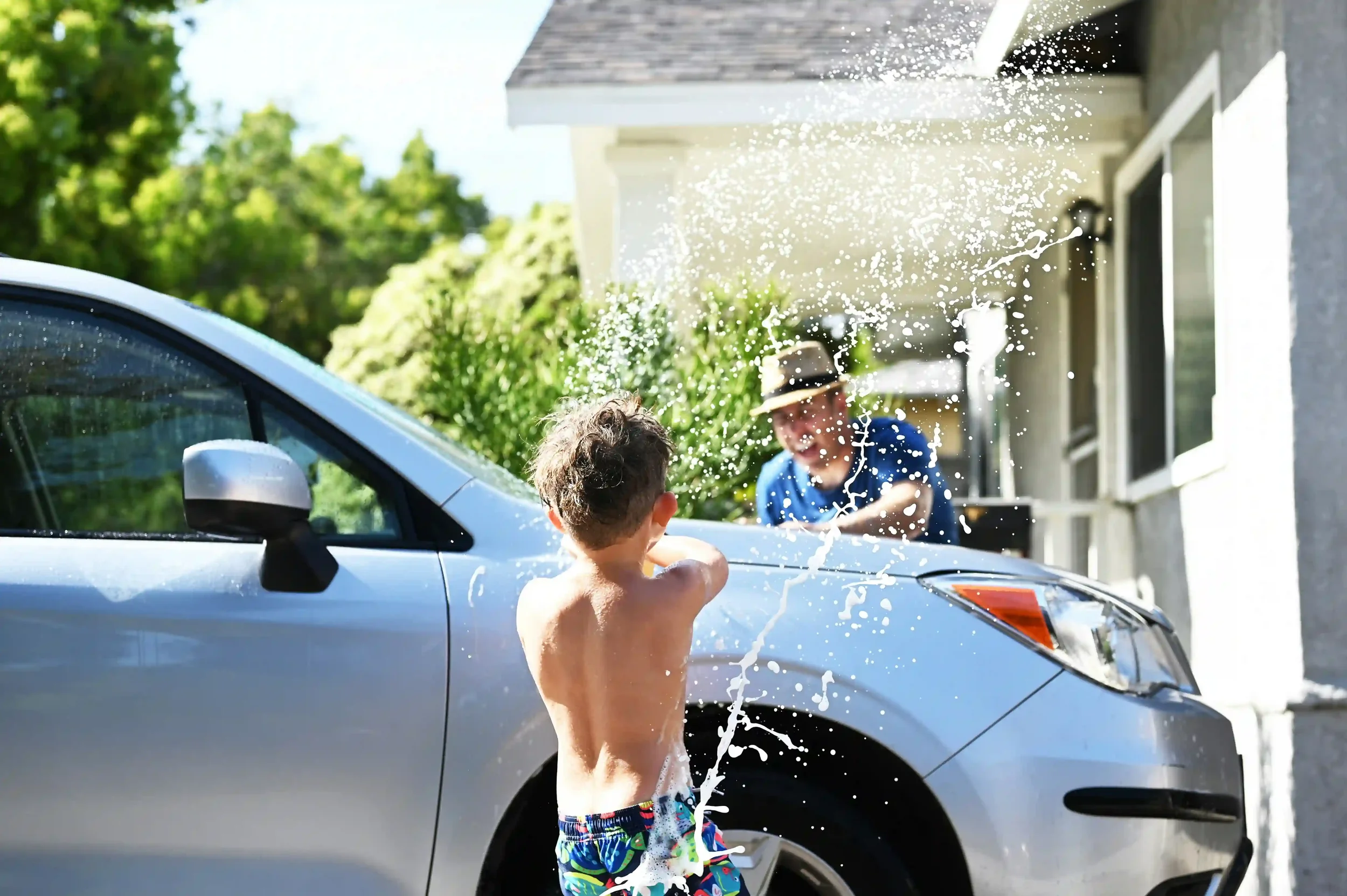 Family washing car in front of Watsonville home