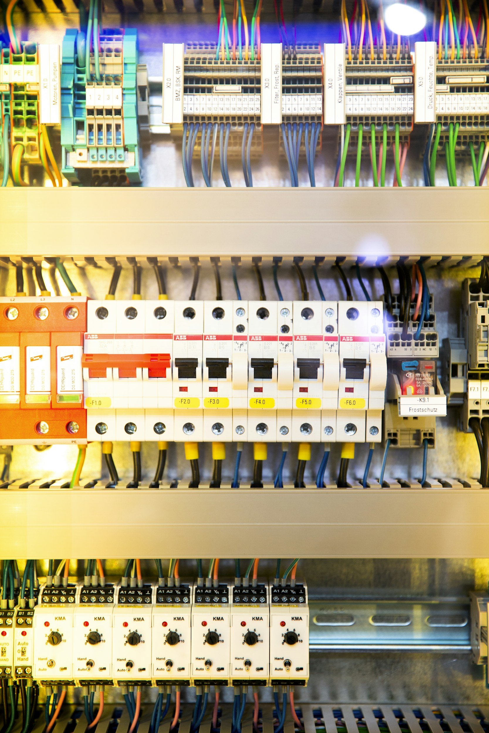 Electrical control panel with various circuit breakers, wiring, and labels.