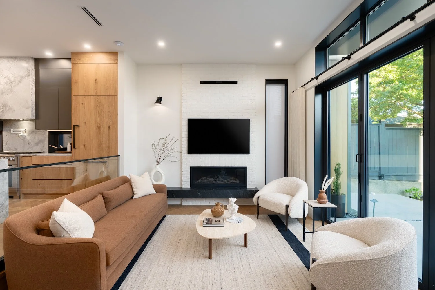 Layered textures and neutral furnishings in the living room of a Point Grey property.