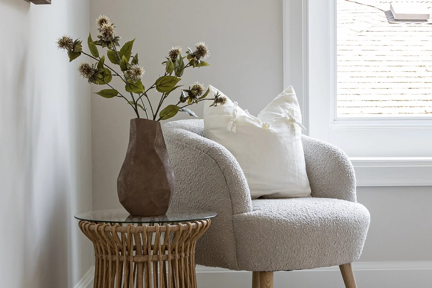 Staged reading nook with a boucle armchair and botanical styling - luxury home staging in Burnaby by The Design Alchemist