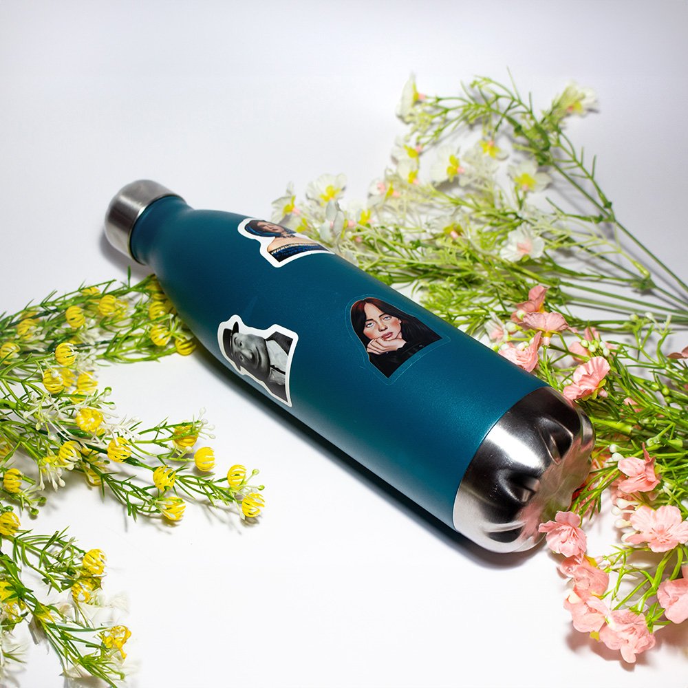 Blue thermos with stickers of women and surrounded by yellow, white, and pink flowers on a white background.