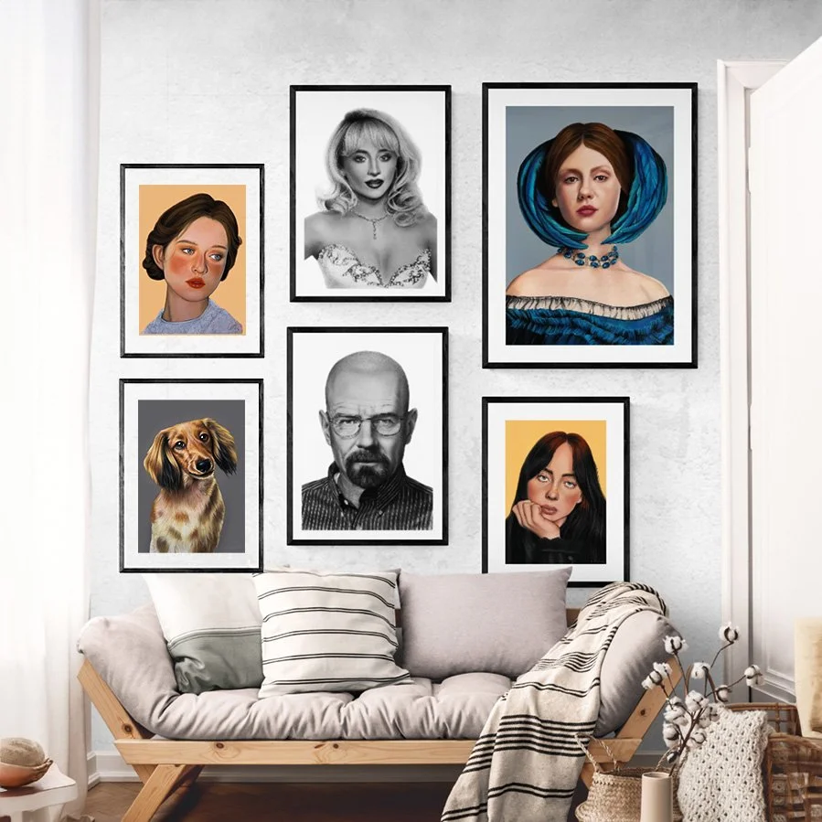 A gallery wall with six framed portraits, including illustrations of women, a black-and-white photograph of a man with glasses, a color photograph of a dog, and a digital painting of a woman with blue hair, above a beige couch with striped cushions in a living room.