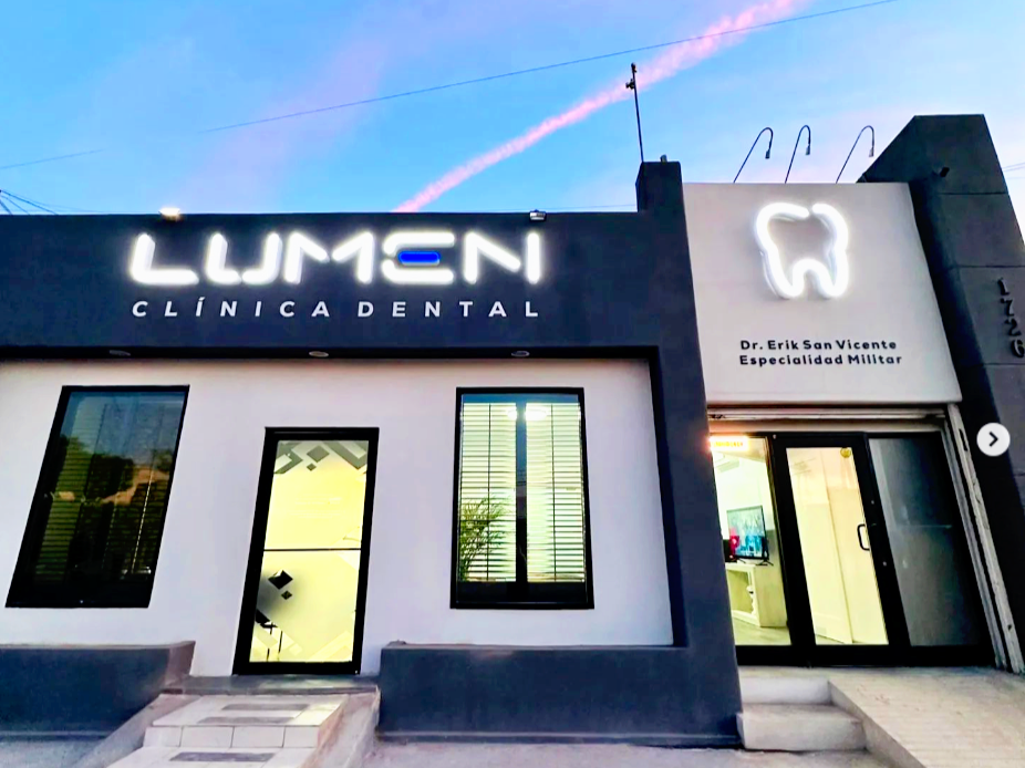 Fachada de una clínica dental llamada LUMEN con un letrero de Dr. Erik San Vicente, especialista en medicina militar, y un símbolo de un diente.
