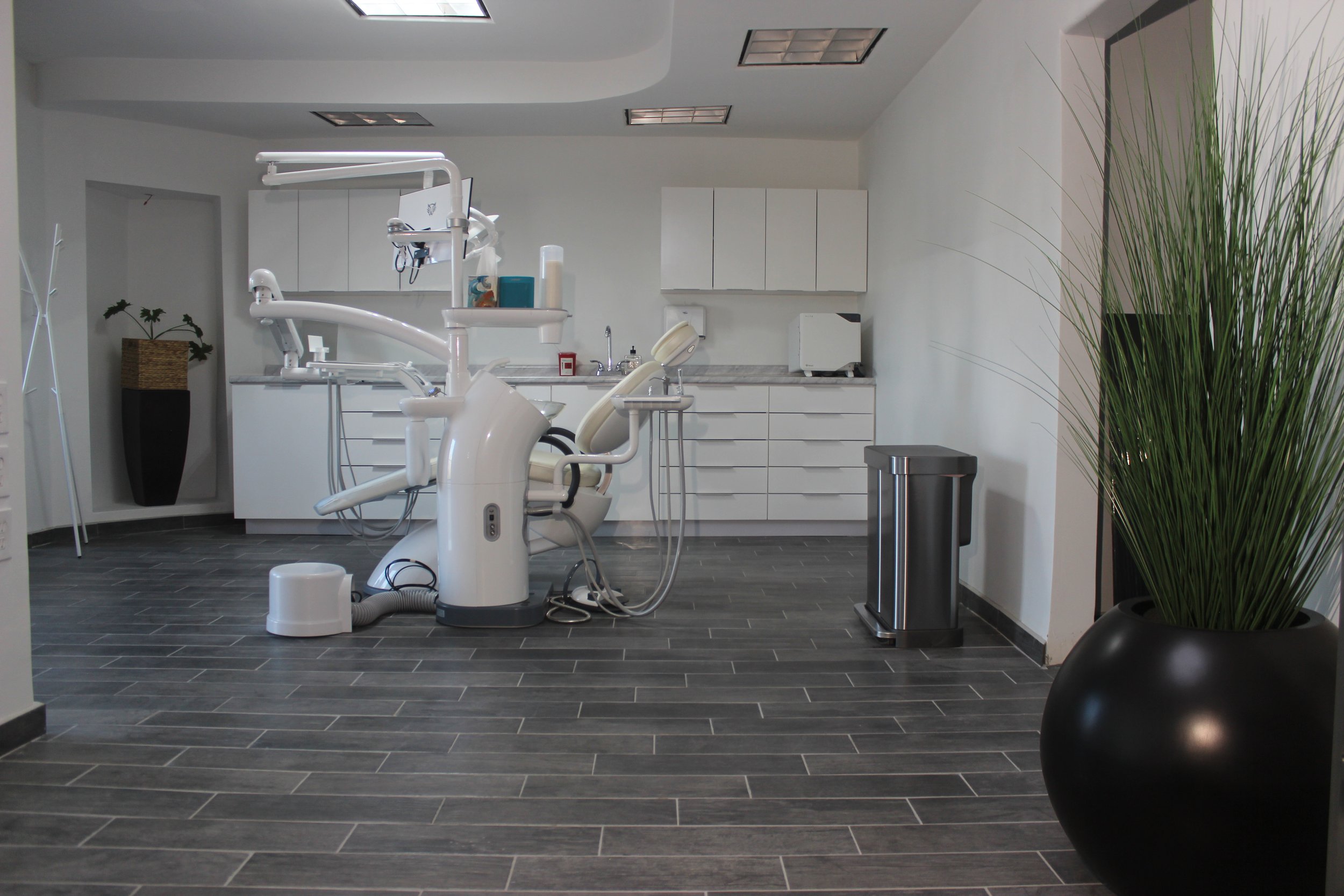 Consultorio dental con silla dental premium, equipo y muebles en un espacio moderno, exclusivo y limpio.