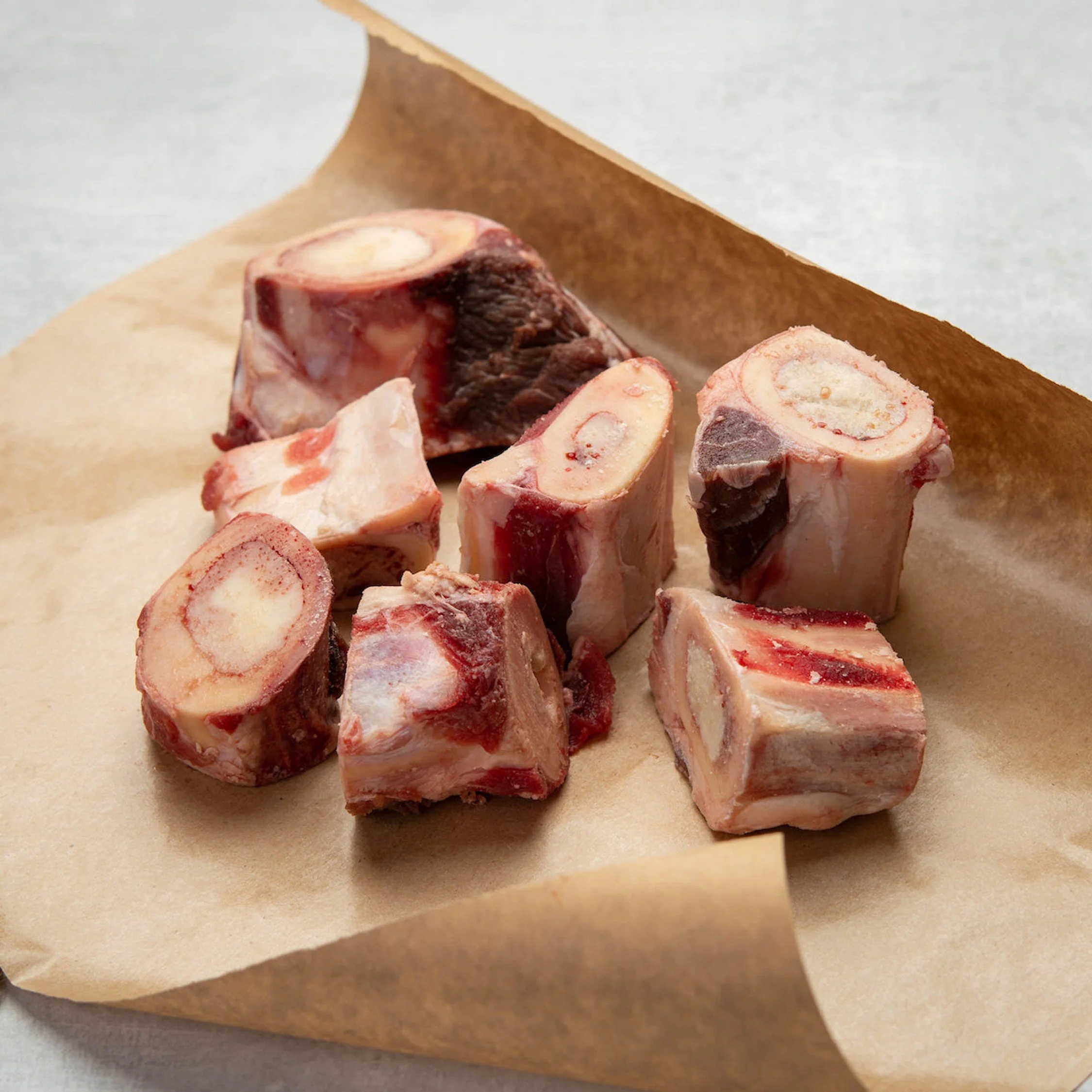 Piece of raw beef bone marrow on brown parchment paper