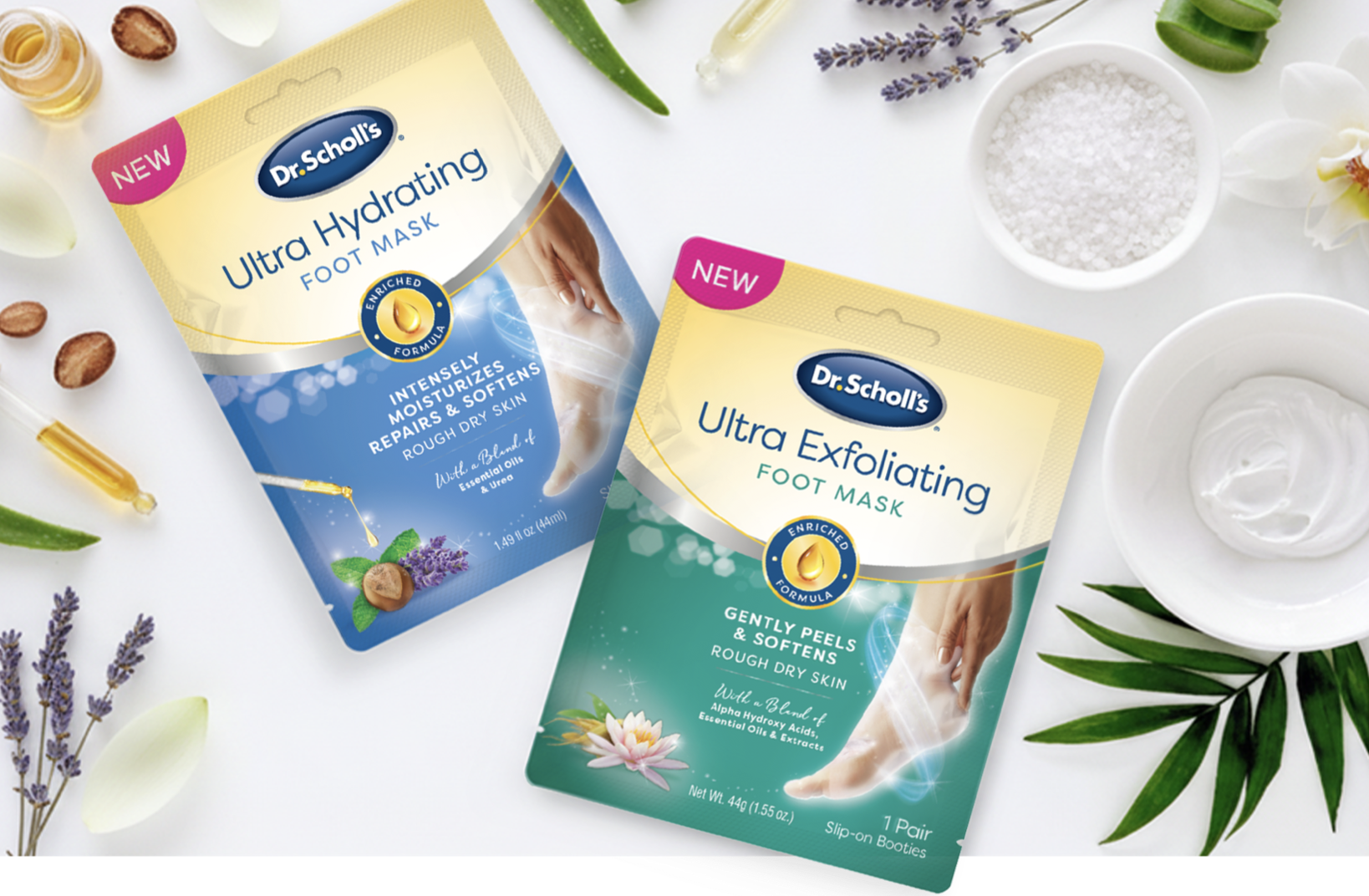 Two packages of Dr. Scholl's foot masks, one labeled Ultra Hydrating and the other Ultra Exfoliating, on a white surface along with natural ingredients and decorative elements like lavender, aloe vera, and white flowers.