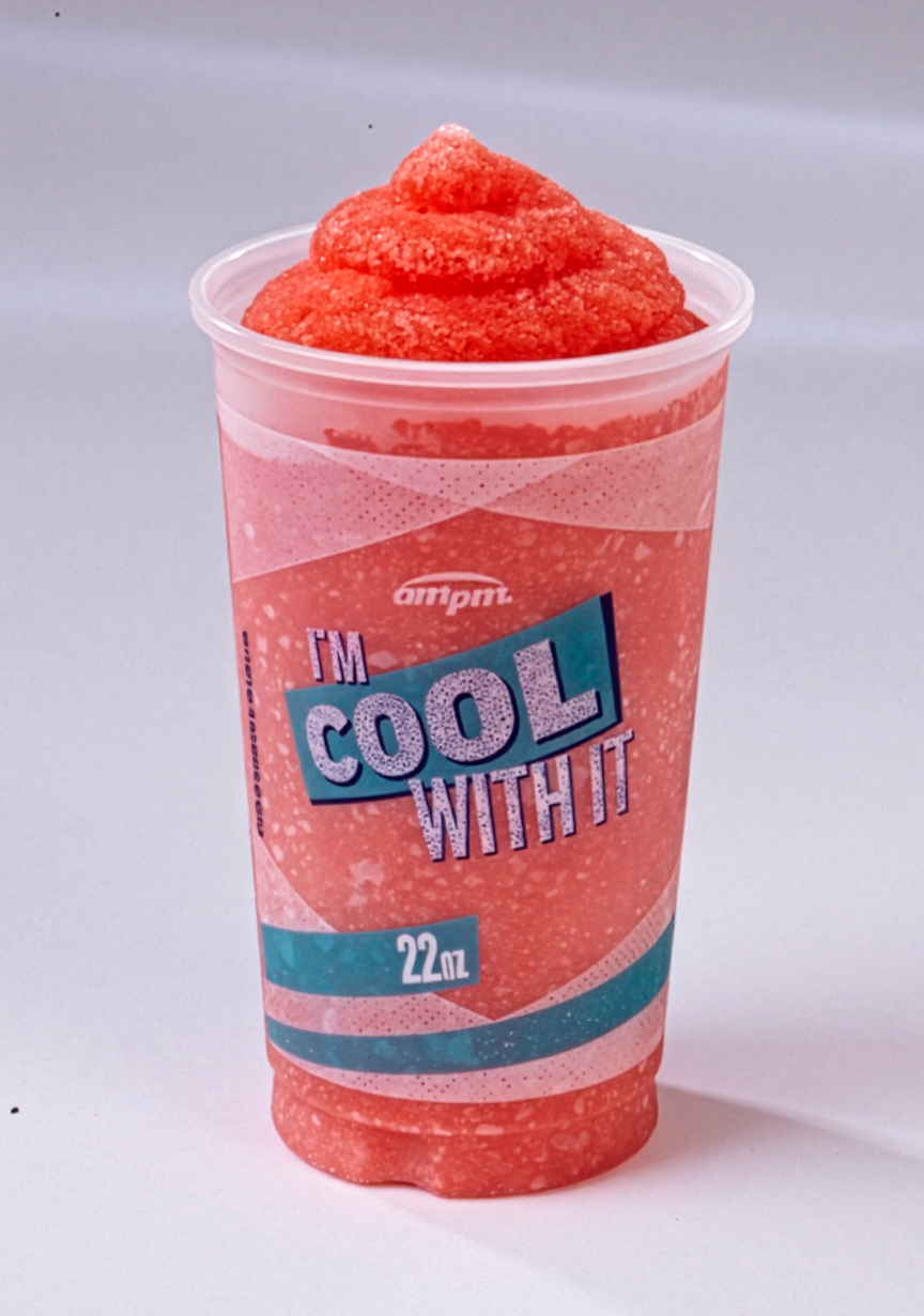 A 22 oz cup of red frozen slush with a label that reads 'I'm Cool With It' and the brand name 'ampm' under a clear plastic lid.