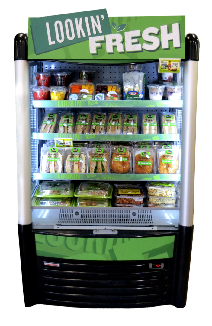 Refrigerator display with sandwiches, salads, desserts, and beverages, labeled under a "LOOKIN' FRESH" sign.