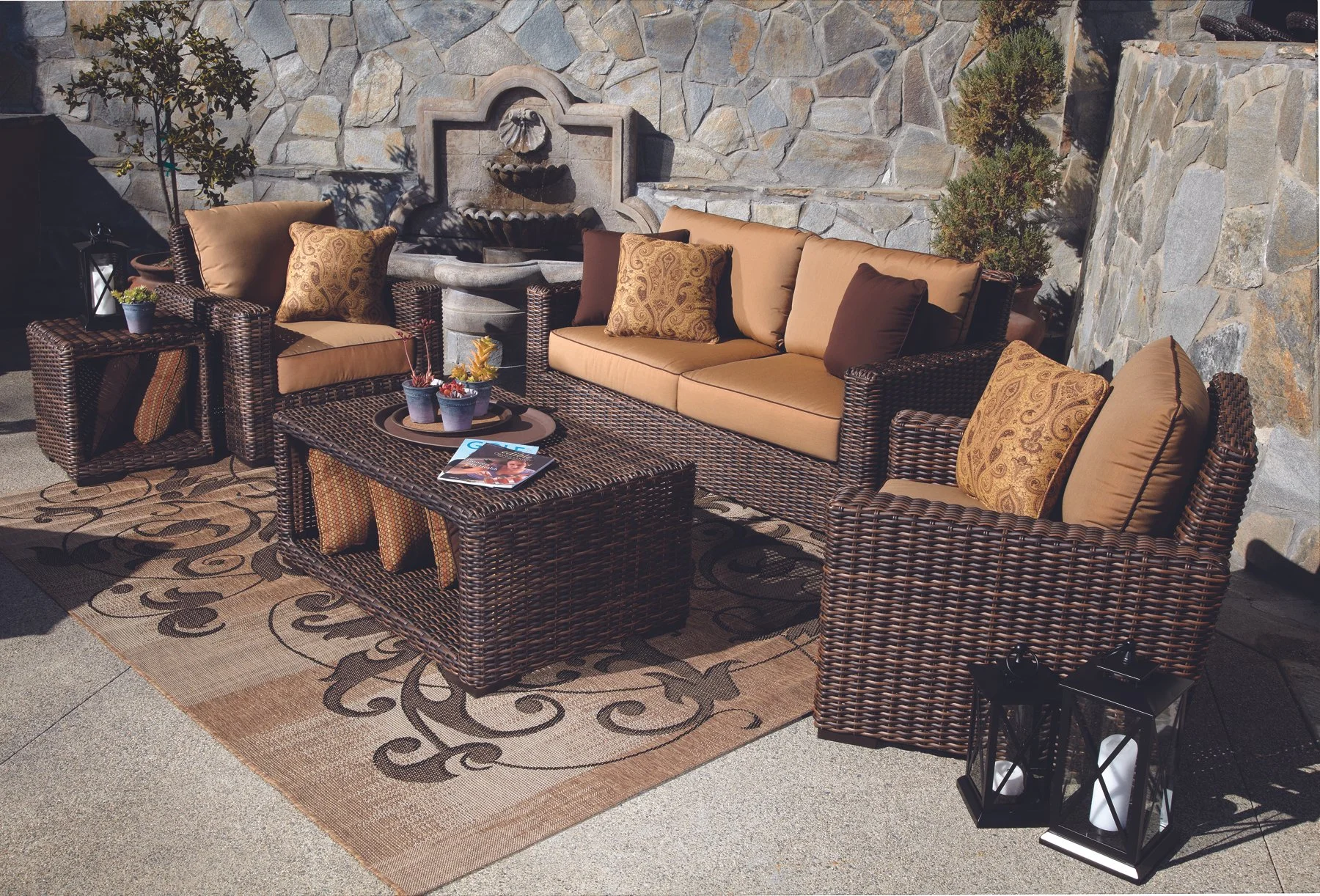 White outdoor sectional sofa on a concrete patio in a backyard with green trees and bushes.