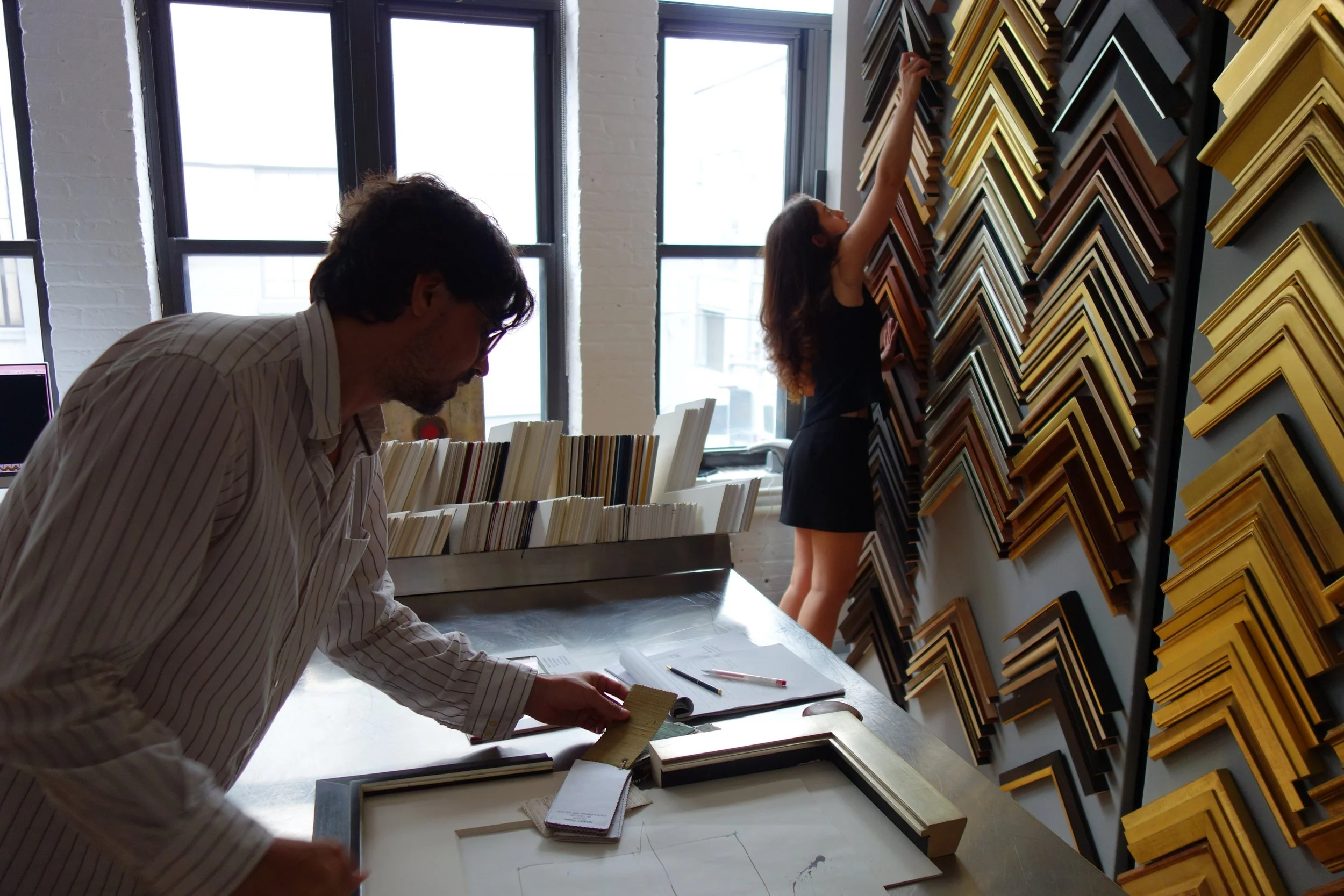 Client selecting museum-grade frame moulding for fine art at Paris Frames NYC showroom