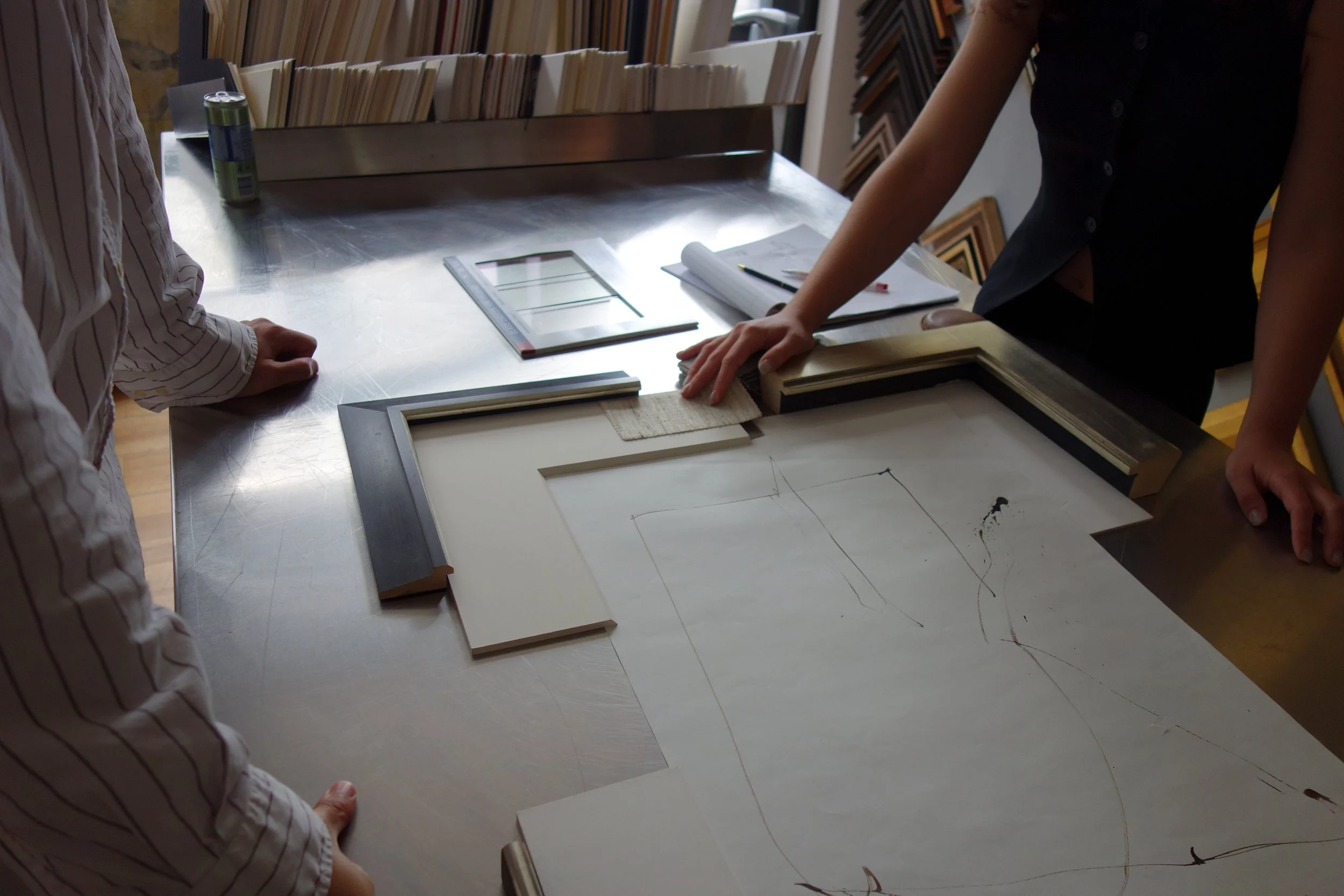 Custom framing consultation at Paris Frames NYC — client reviewing frame samples in Long Island City showroom
