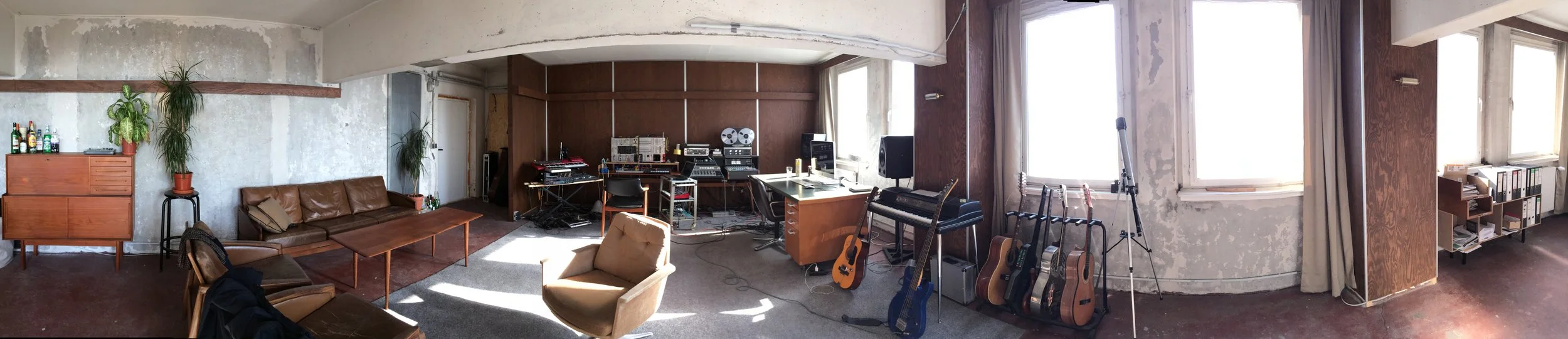 Music studio with guitars, recording equipment, and seating area