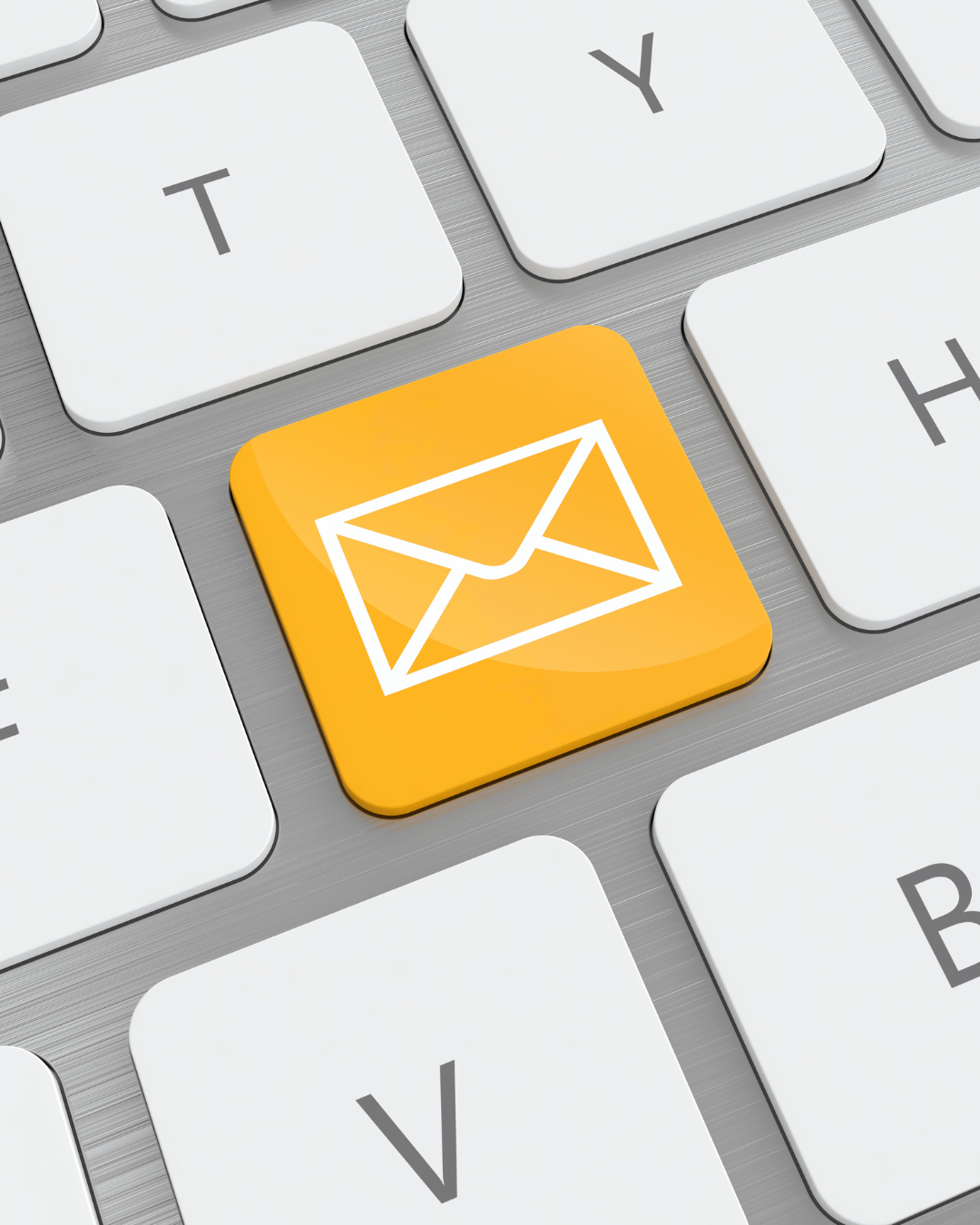 Close-up of a computer keyboard with a yellow key featuring a white envelope icon, indicating email function.