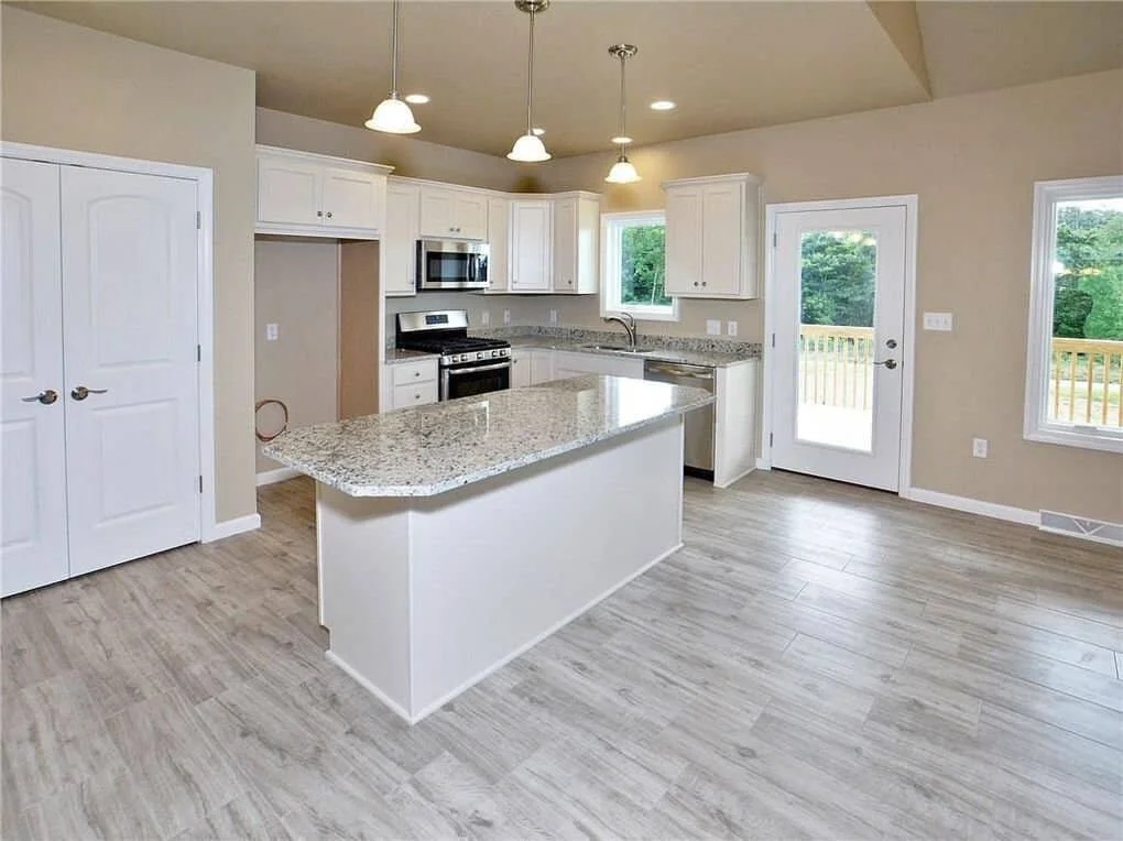 Kitchen cabinets with custom countertops, range, dishwasher, microwave and disposal