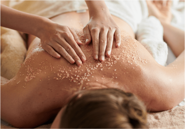 Person receiving a salt scrub massage on their back.