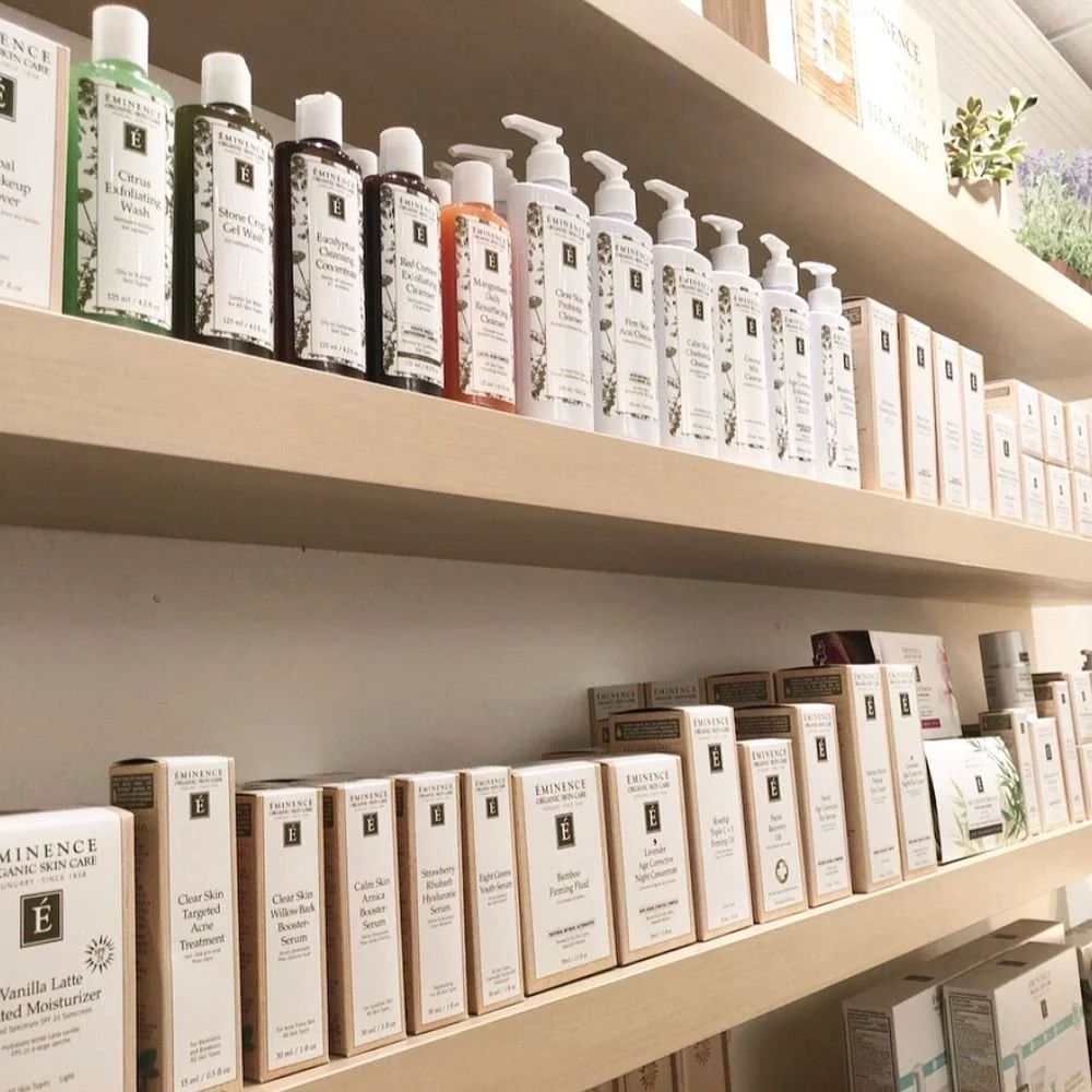 Shelf stocked with skincare products, including cleansers and serums, in a retail store.